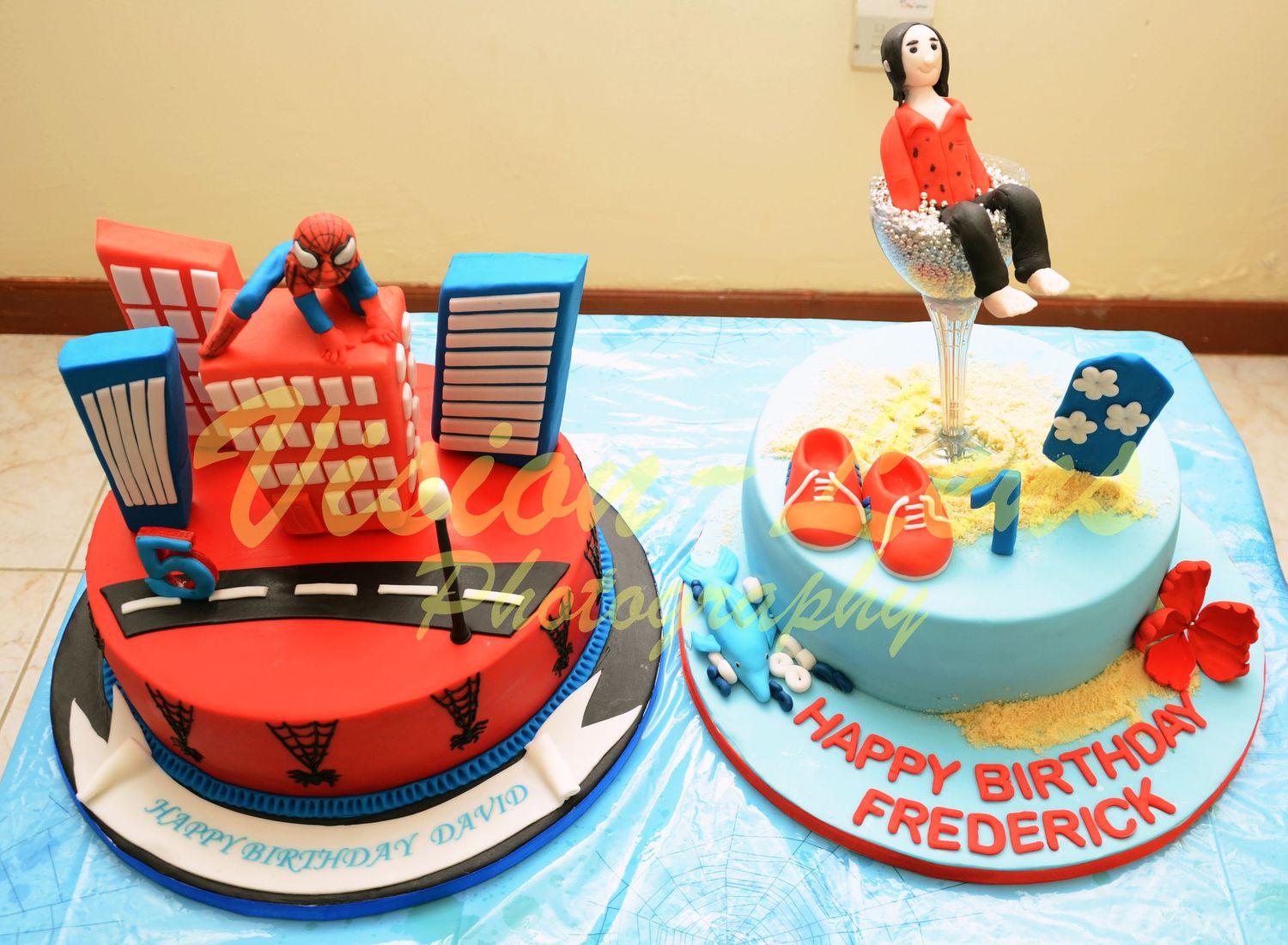 Two colorful birthday cakes decorated with Spiderman and tropical themes for Frederick's celebration.