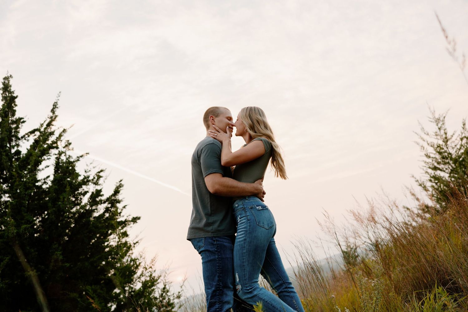 Two people share an intimate moment while standing together in a scenic natural setting. sioux falls photographer riley ro photo