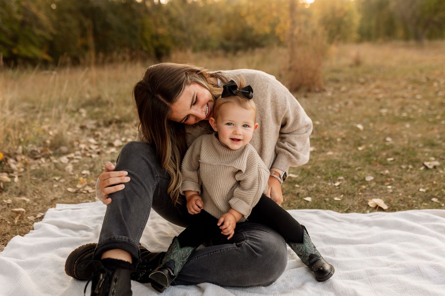 A heartwarming moment shared on a blanket in a sunlit autumn field during golden hour. Riley Ro Photo Sioux Falls, SD