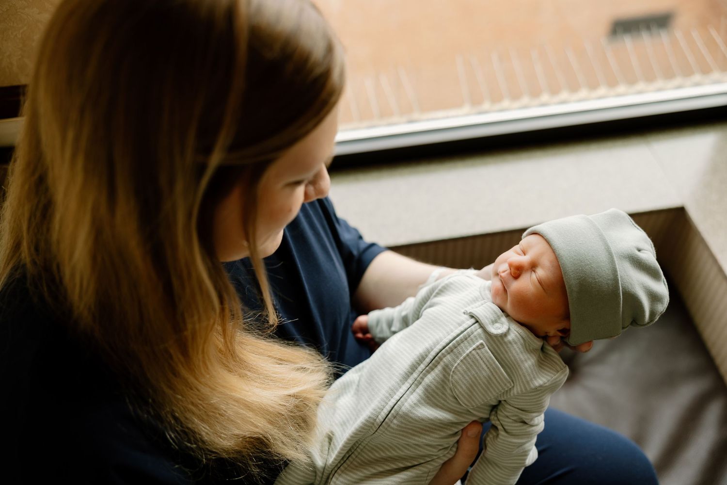 A tender scene of a caregiver holding a small infant dressed in white clothing.