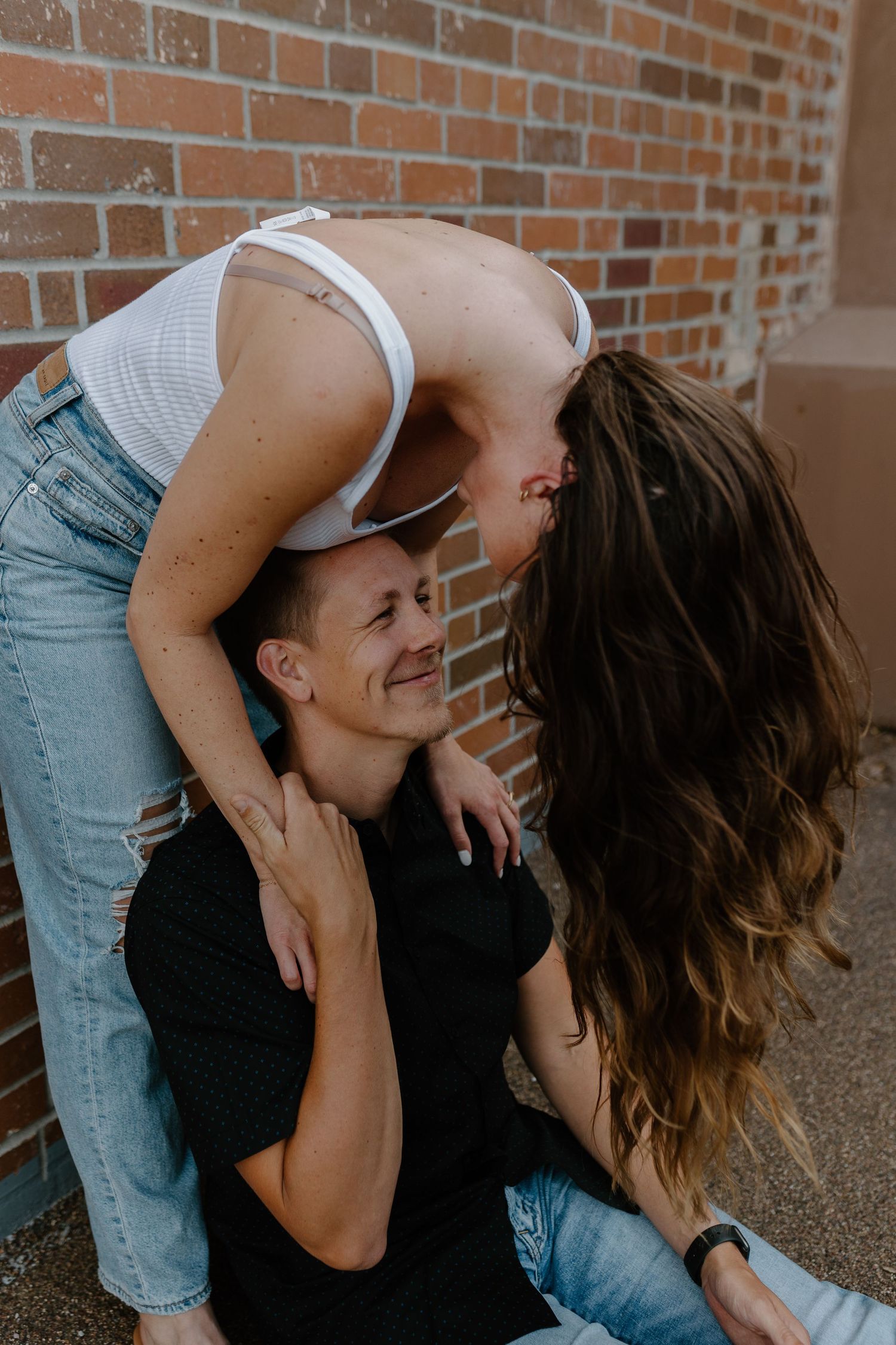 A playful couple embracing and laughing against a brick wall backdrop.
Sioux Falls Photographer  
Evermore Photo Co