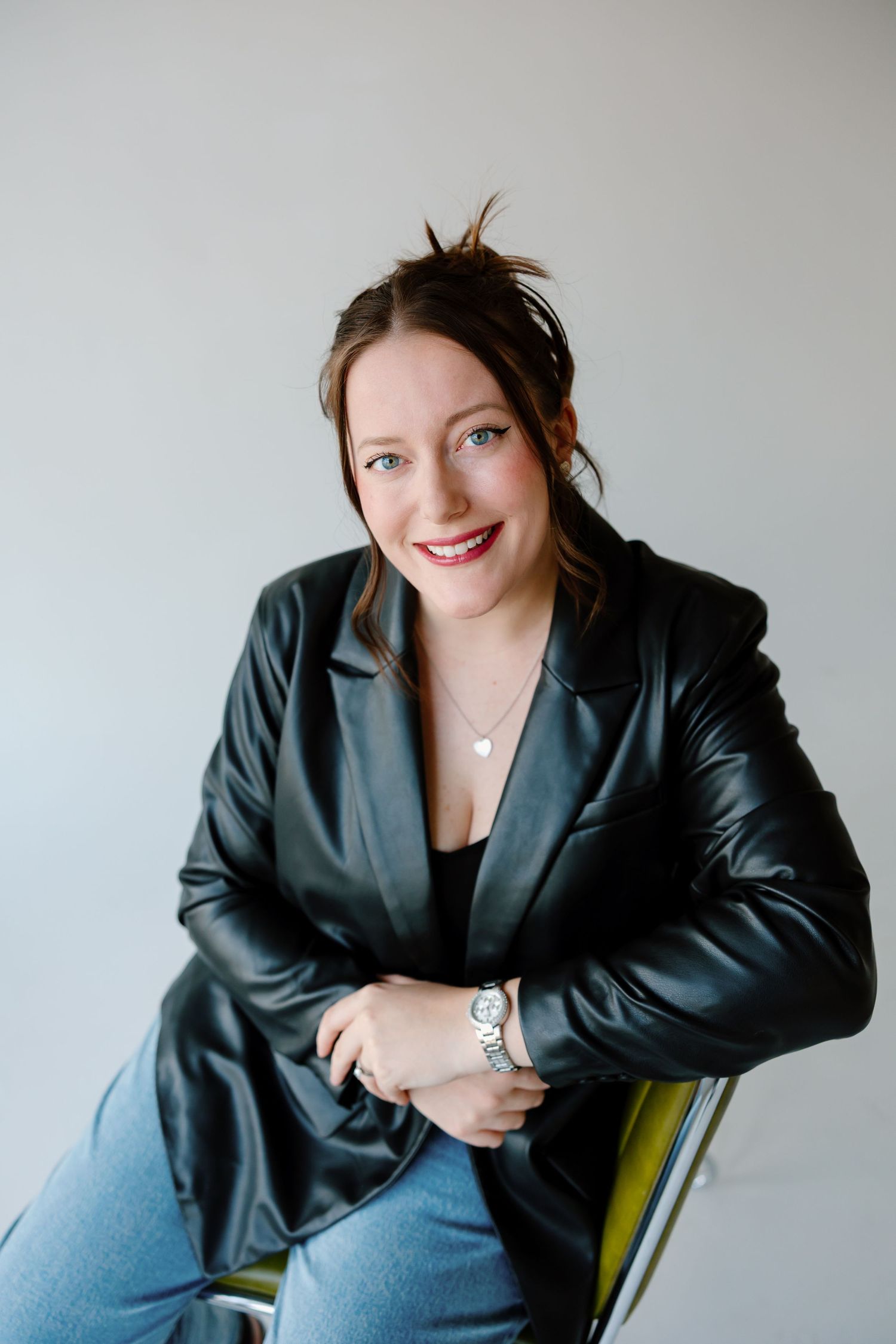 A series of professional headshots showing someone in a black leather blazer posing against a light background.