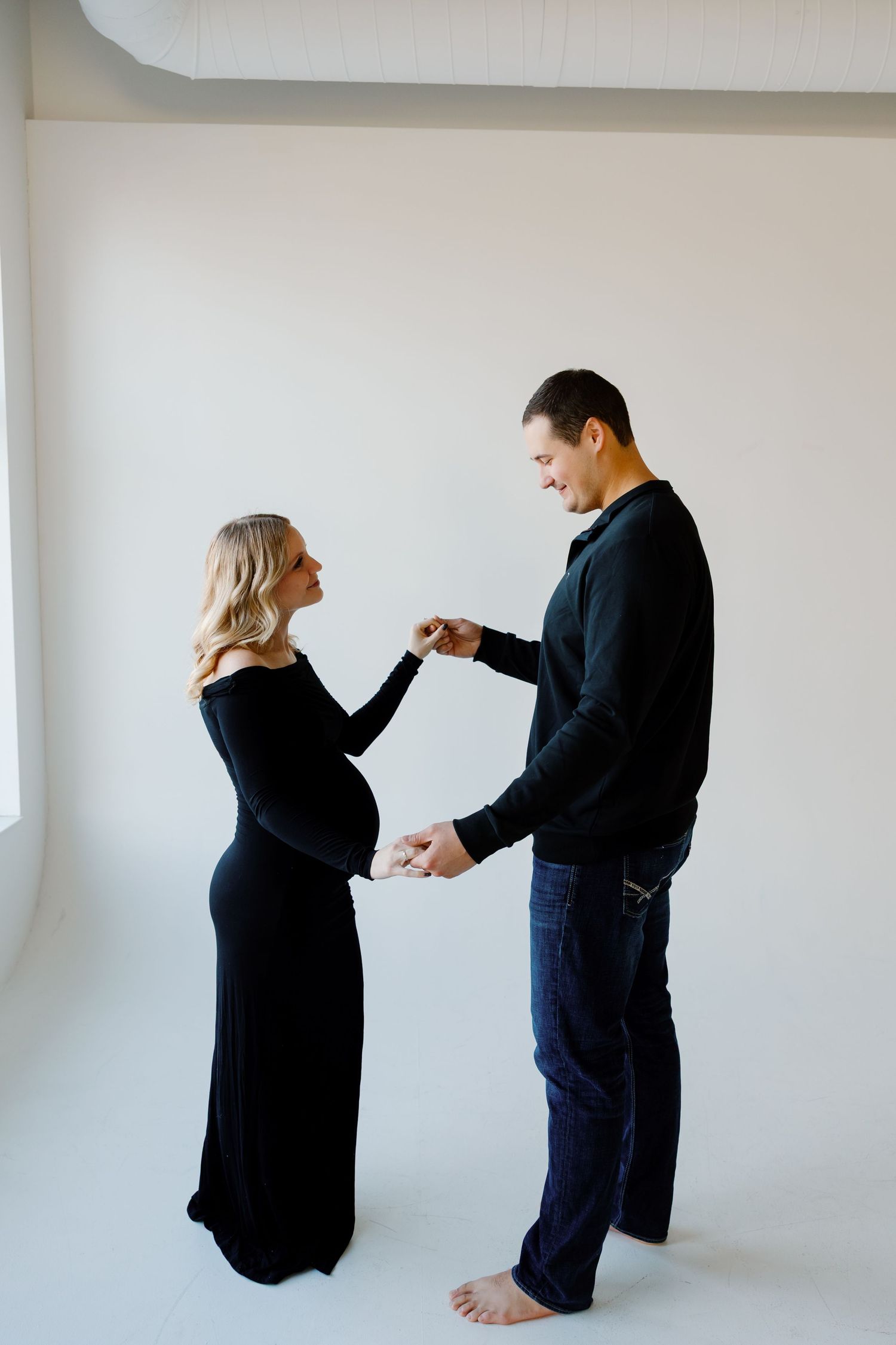 A couple shares tender moments in a minimalist setting wearing coordinating black outfits. Riley Ro Photo Sioux Falls, SD