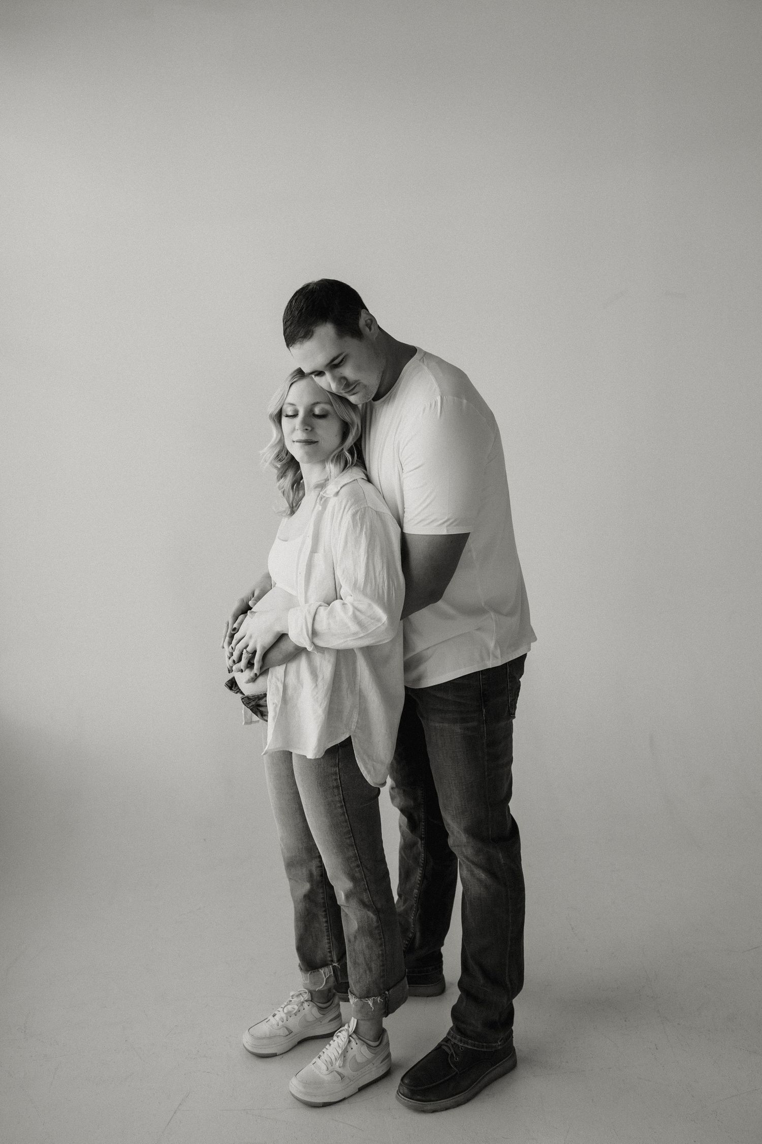 A series of black and white photos showing two people in an intimate embrace against a plain background. Riley Ro Photo Sioux Falls, SD