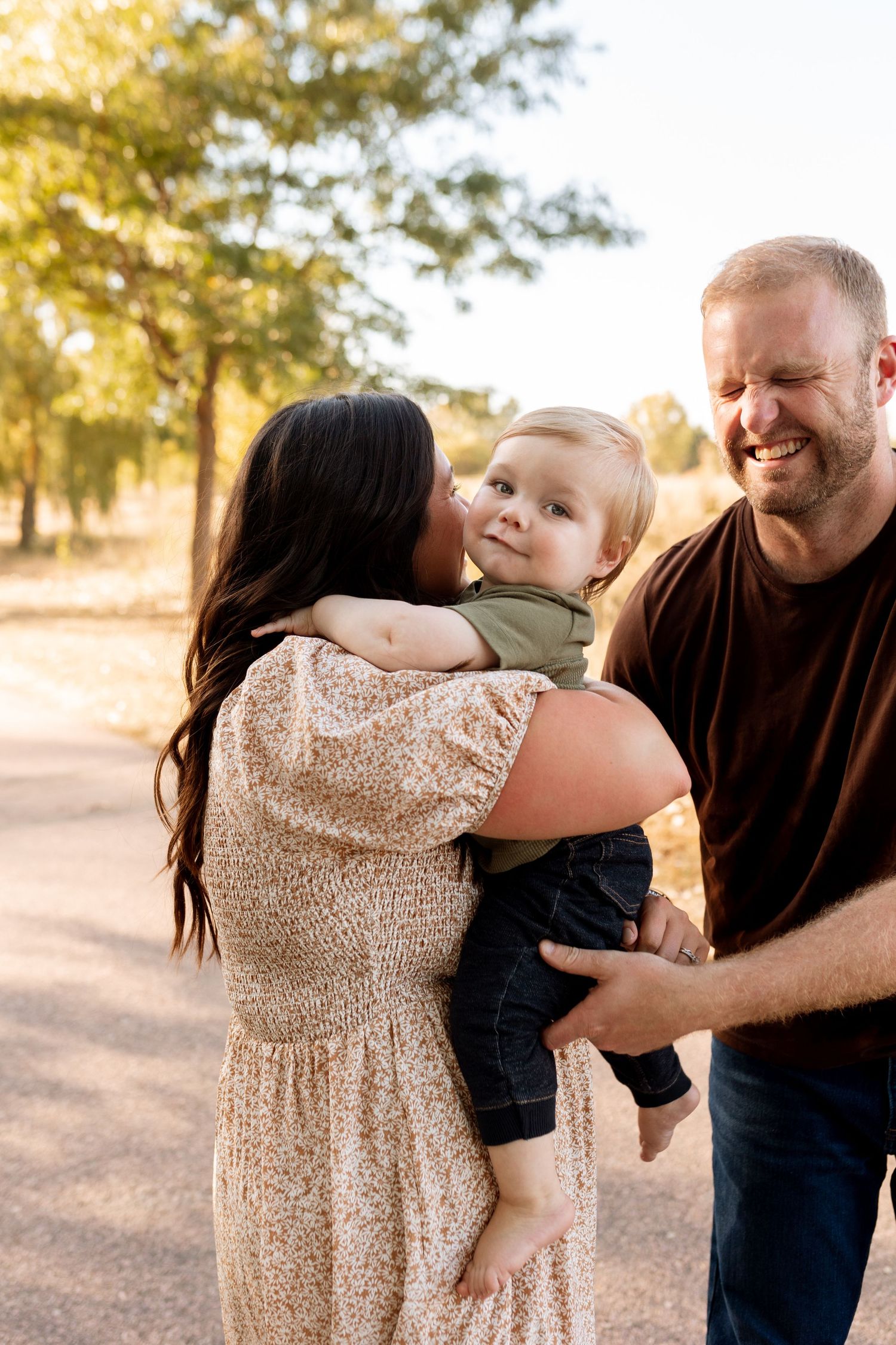 Family sharing tender moment outdoors during golden hour sunset.