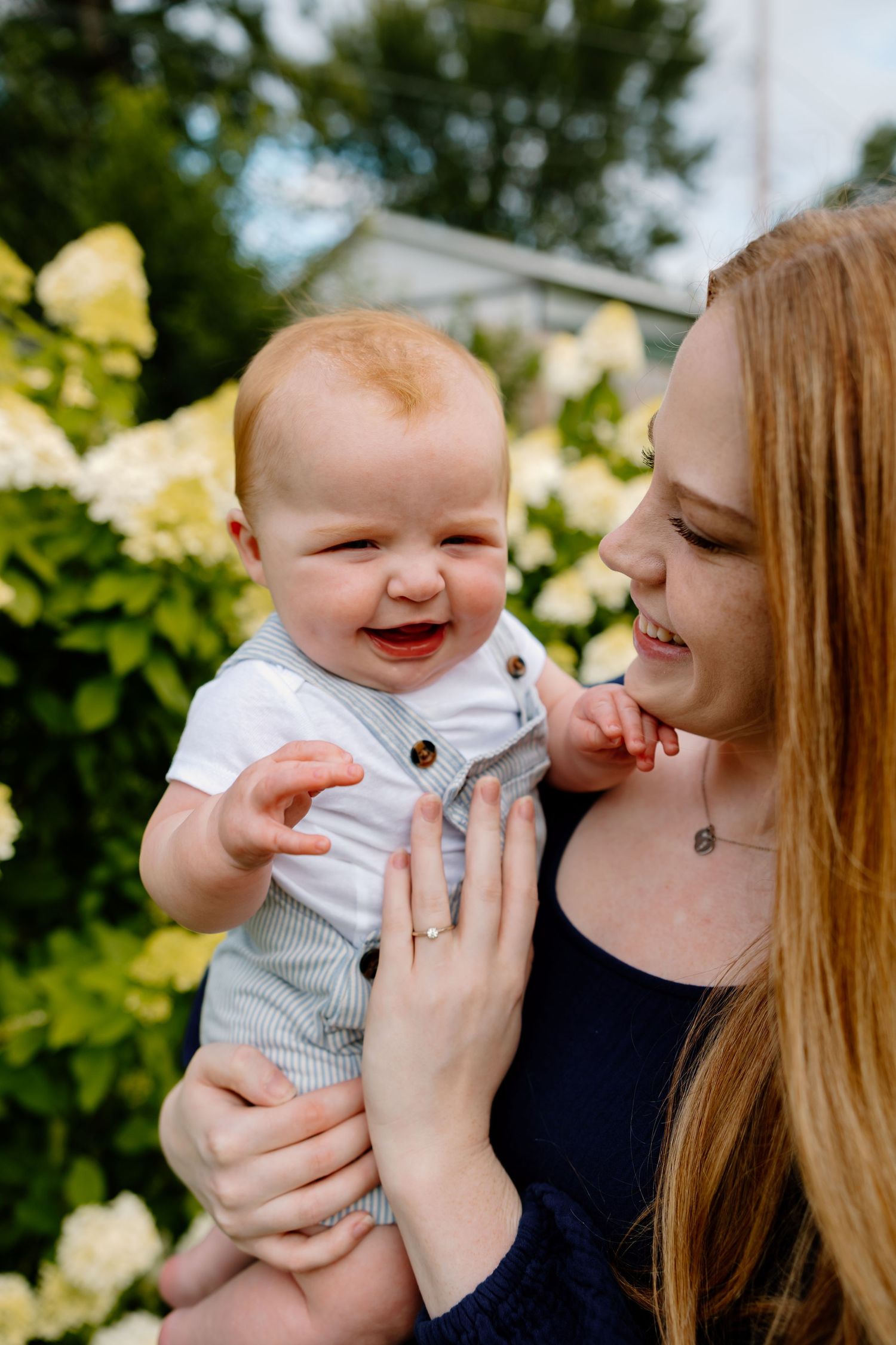 A heartwarming series of candid moments between a parent and baby outdoors with yellow flowers in the background. Riley Ro Photo Sioux Falls