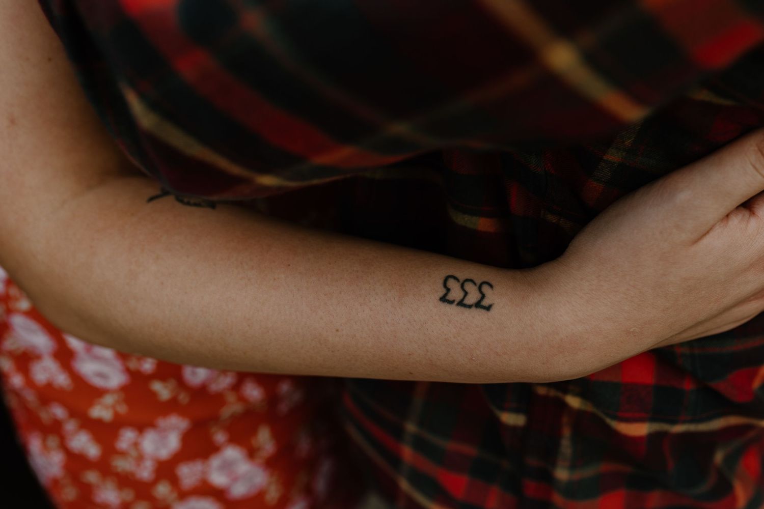 Close-up of arm with small tattoo against red plaid fabric background.
Sioux Falls Photographer  
Evermore Photo Co