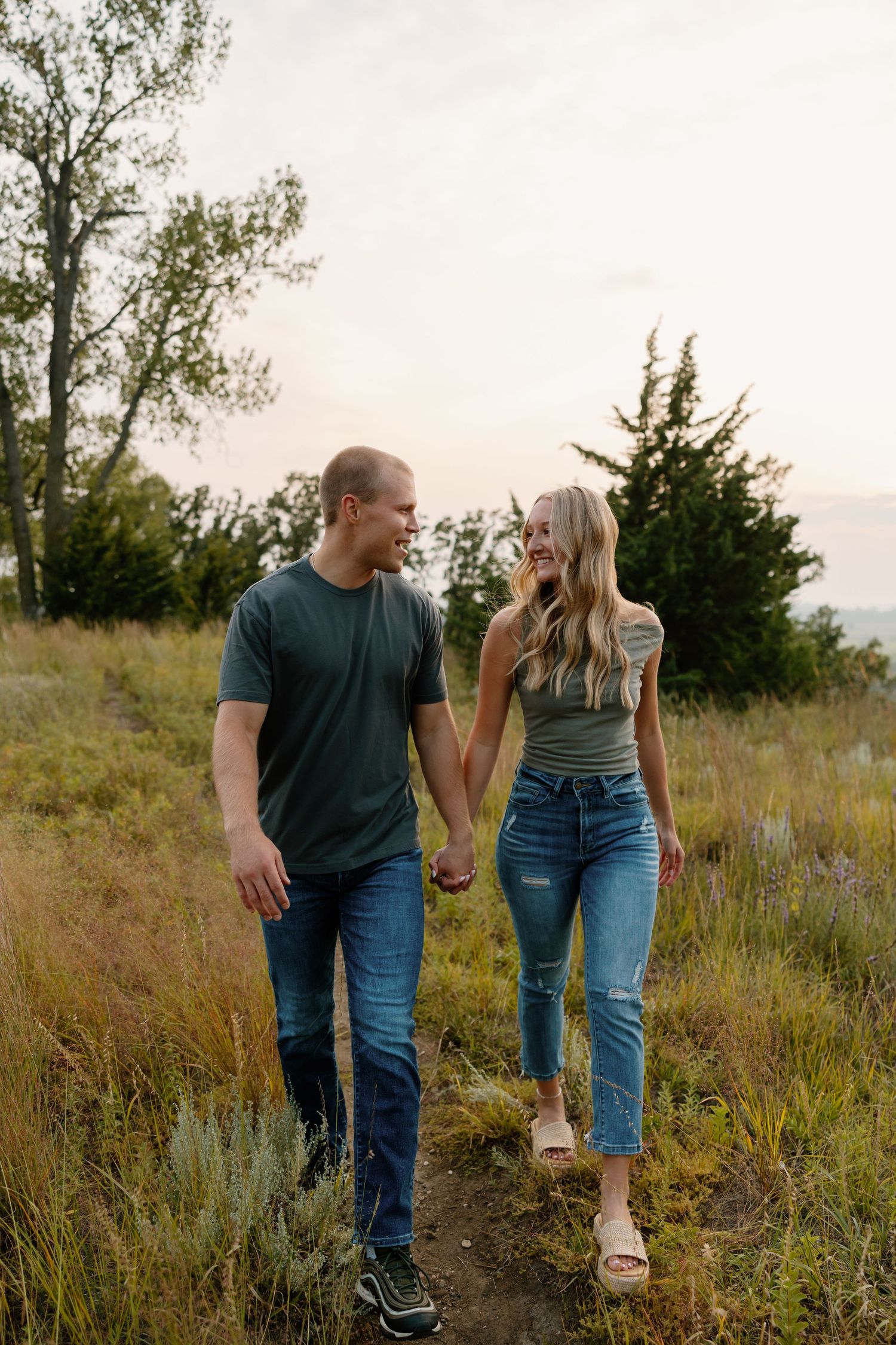 Couple walking together on nature trail through scenic grassland at sunset. sioux falls photographer riley ro photo