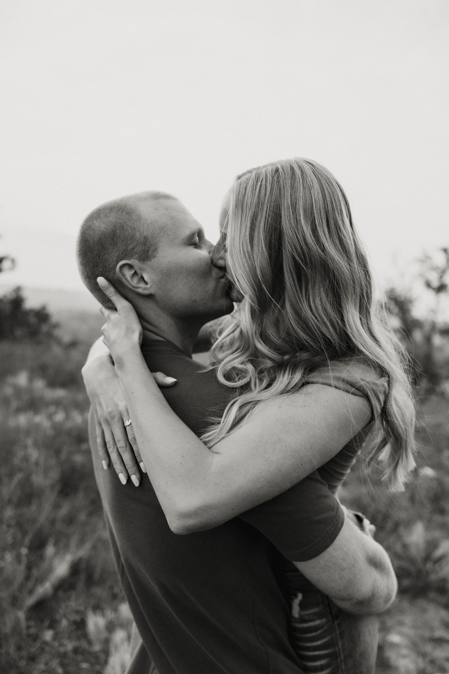 A romantic black and white photo series showing a couple embracing and kissing in nature. sioux falls photographer riley ro photo