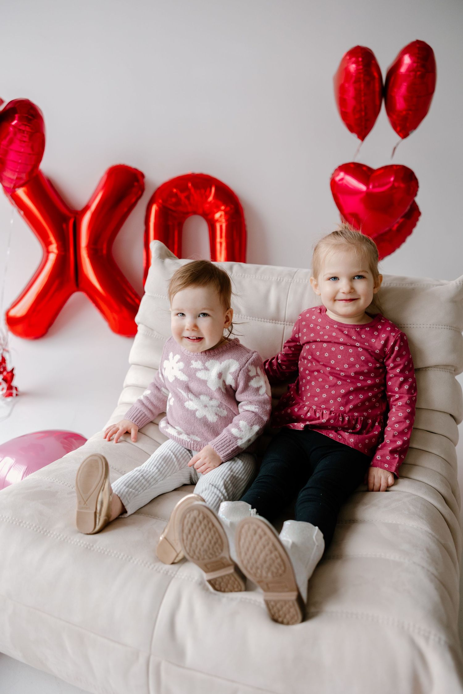 Valentine's Day themed interior with red balloon decorations and cozy seating against a light background.