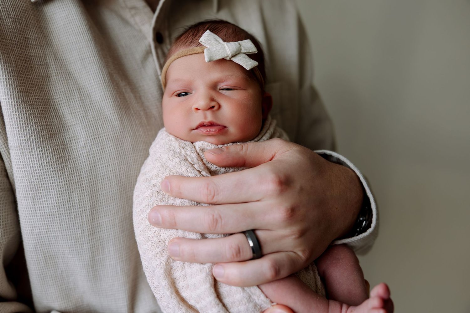 A series of images showing a baby being held in different positions against a light gray background.