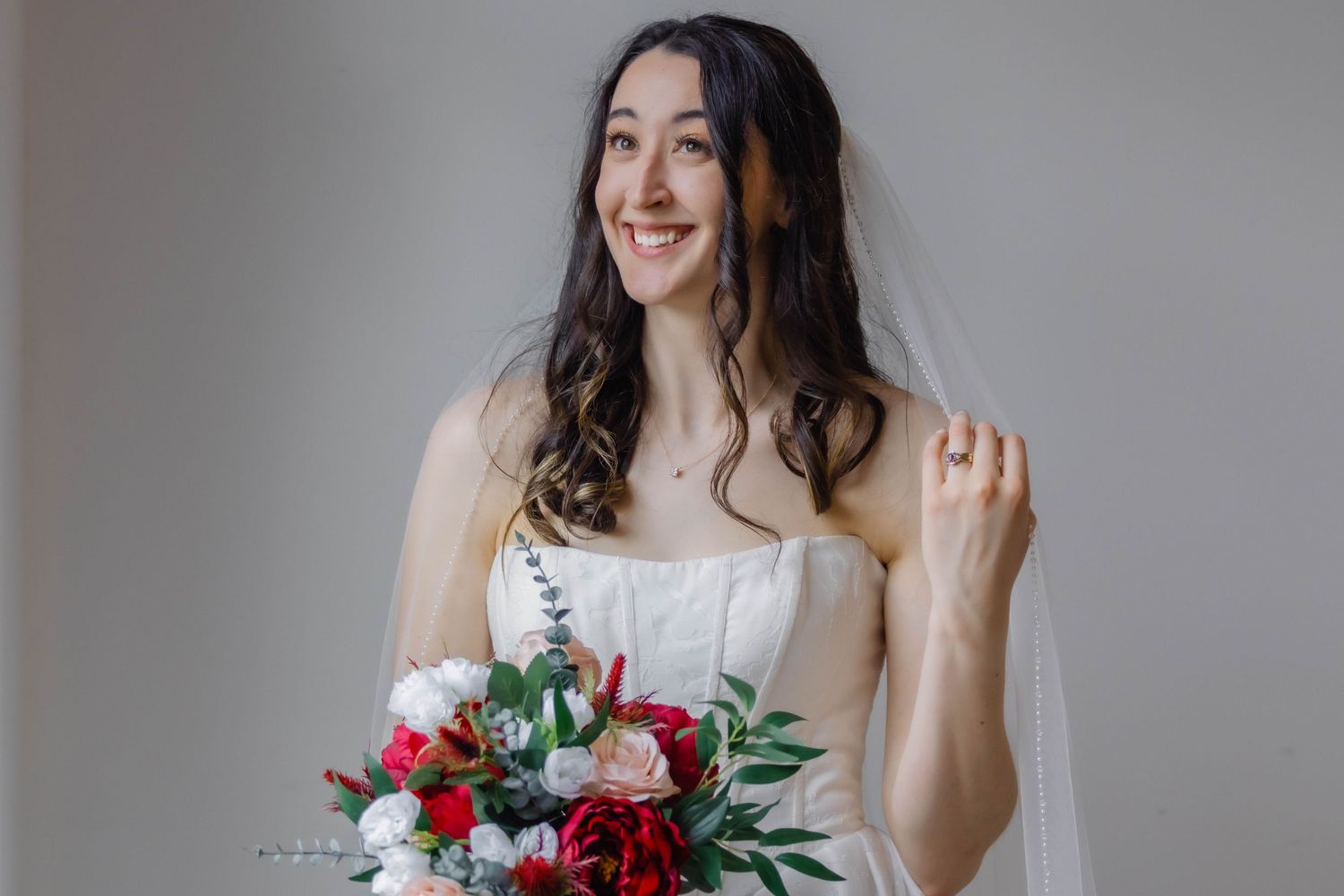 Elegant bridal photos with dramatic red and green floral bouquet.