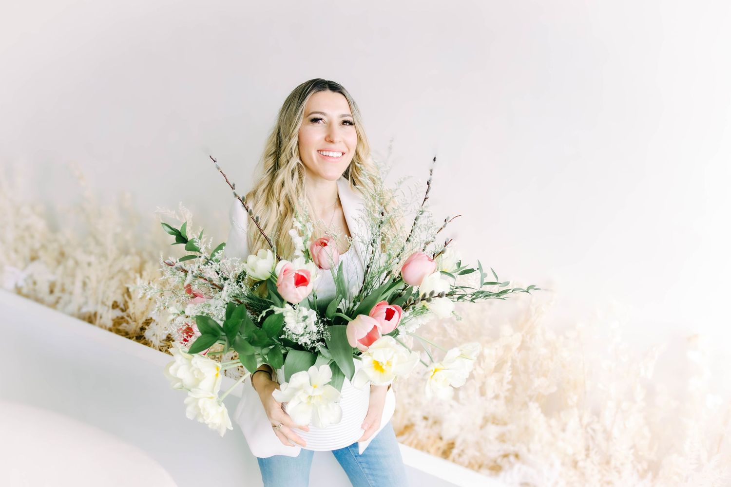 Ethereal studio portrait setup with delicate floral arrangements and soft natural lighting.