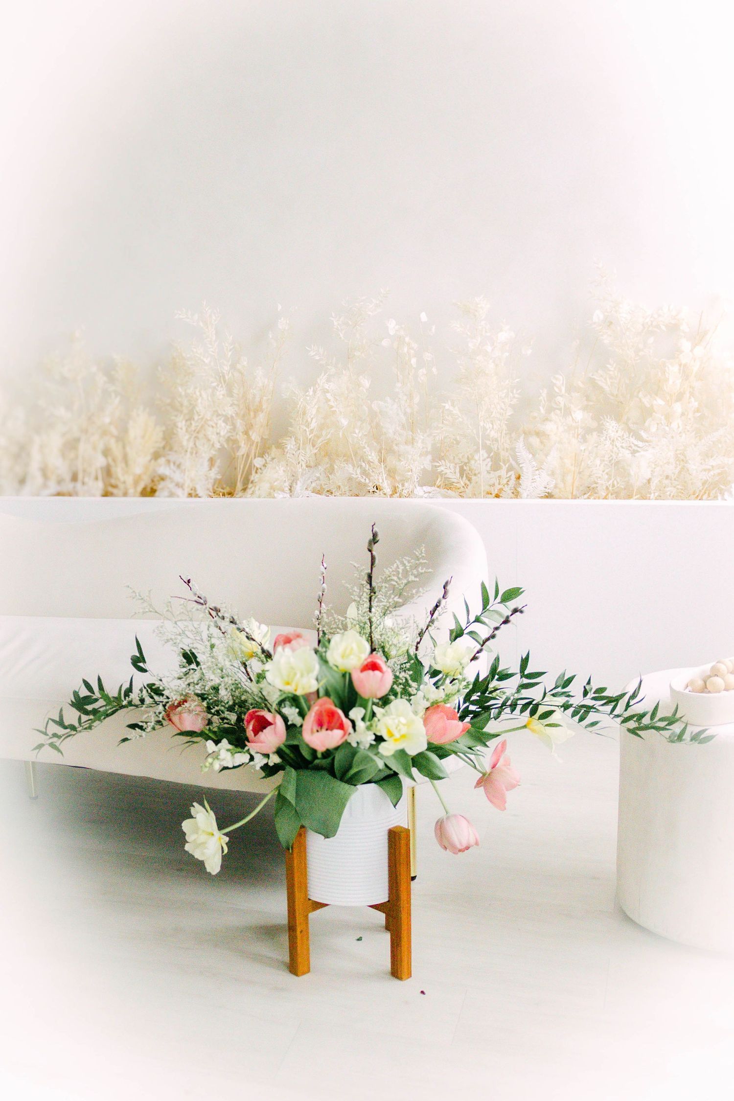 Elegant floral centerpieces with pink and white flowers displayed on wooden stands.