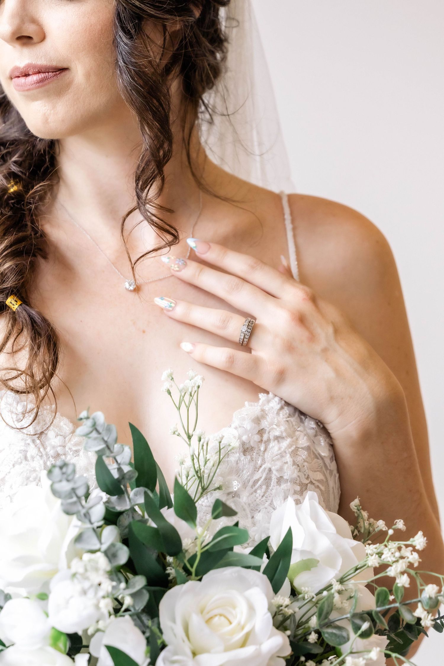 Elegant bridal portrait series showcasing a white floral bouquet and delicate lace wedding dress details.