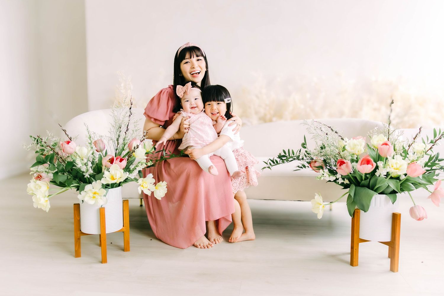 Modern family portrait with pink and white color scheme and decorative floral elements.