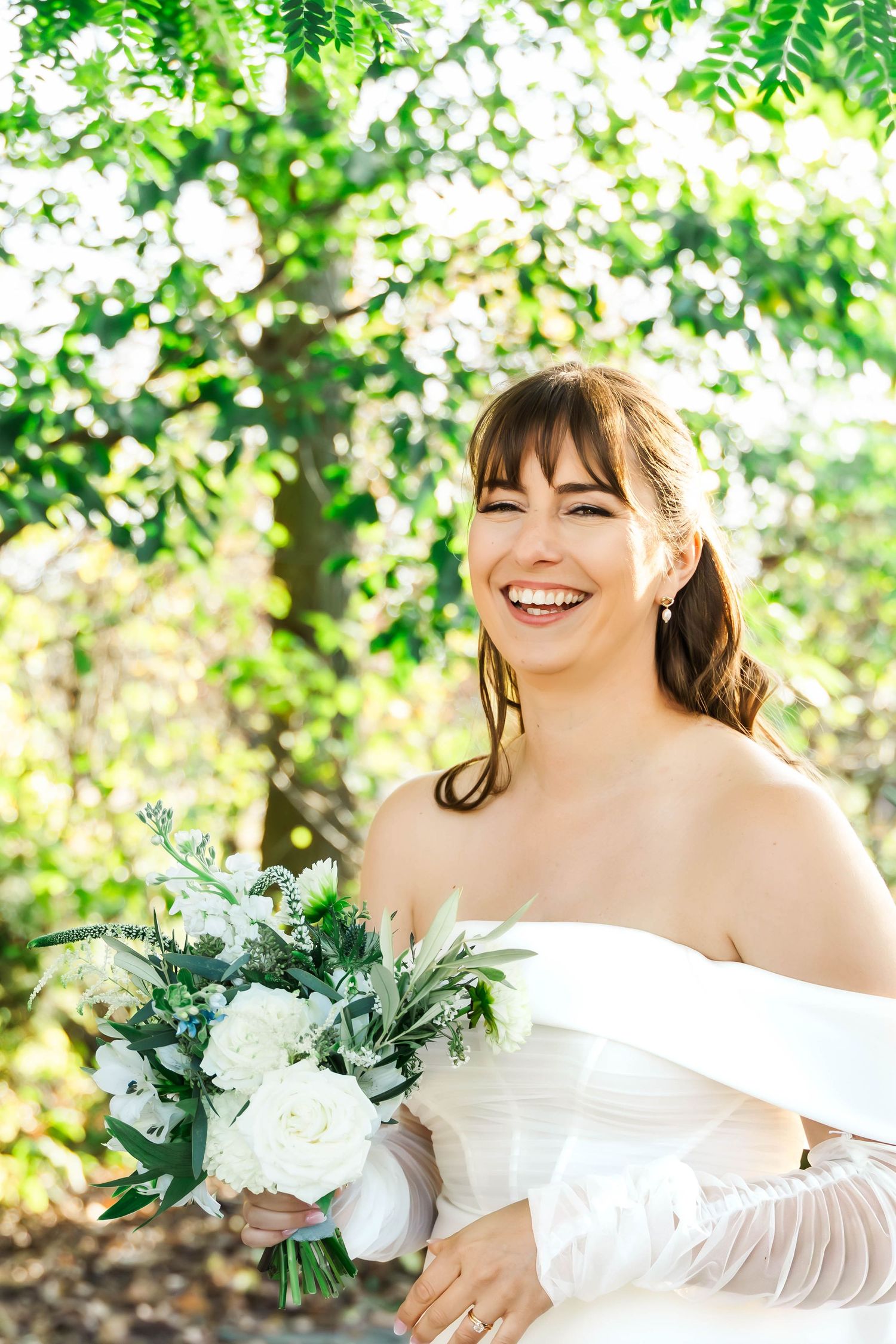 A bridal portrait series showing a white wedding dress and bouquet with greenery against a sunlit natural backdrop.
