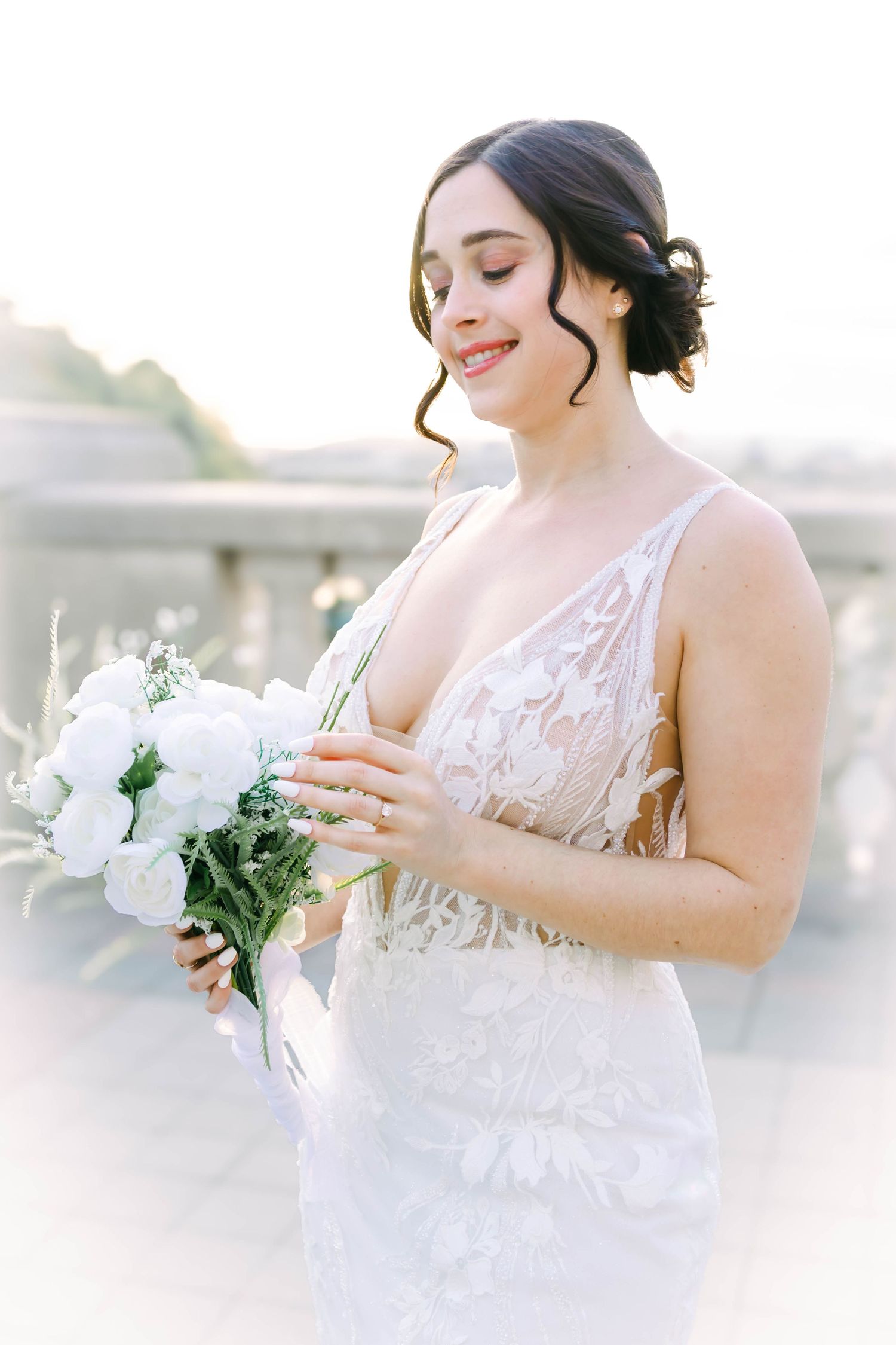 Candid bridal moments captured with white florals and intricate lace dress details.