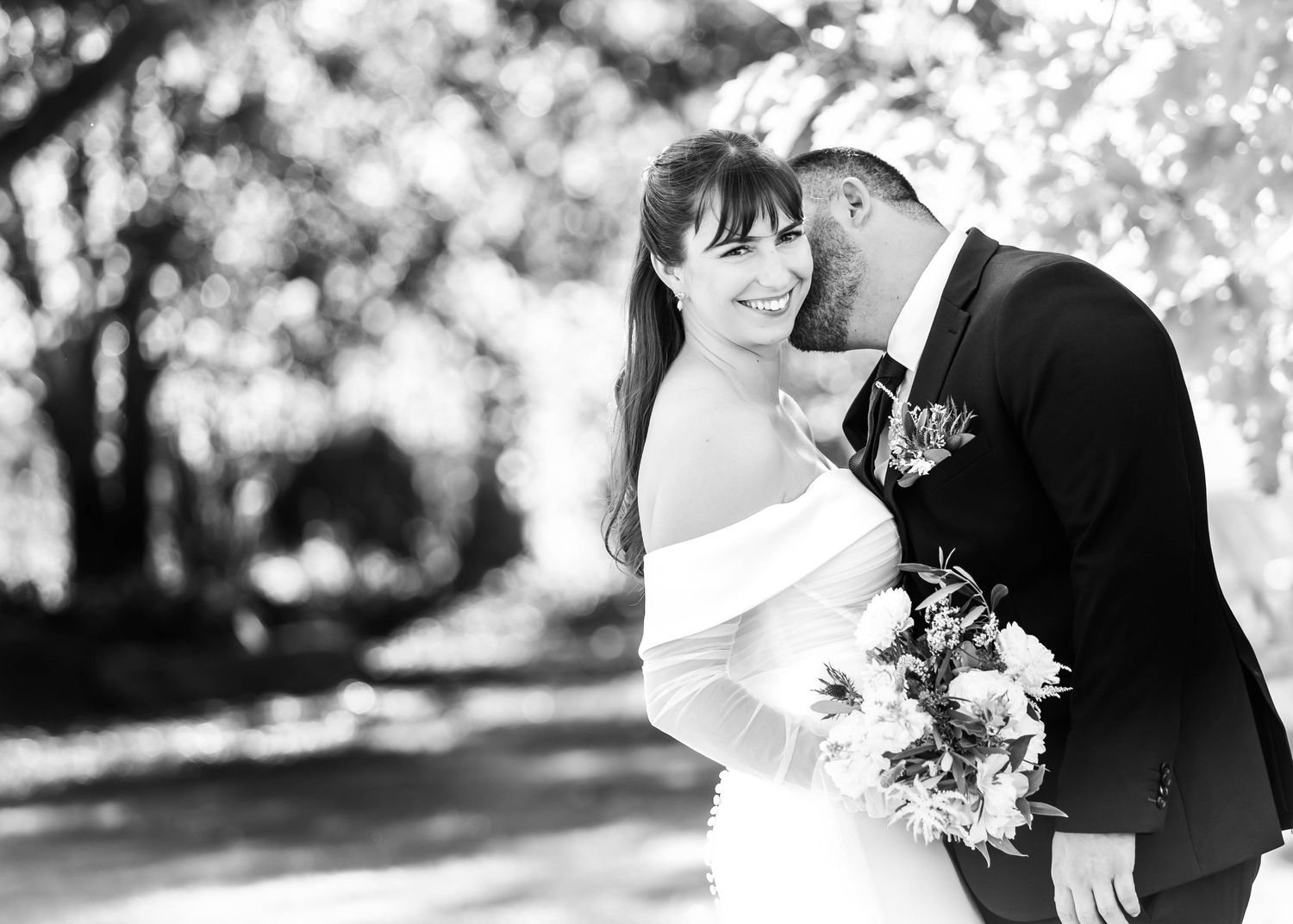 Intimate black and white wedding portraits captured in natural outdoor setting.