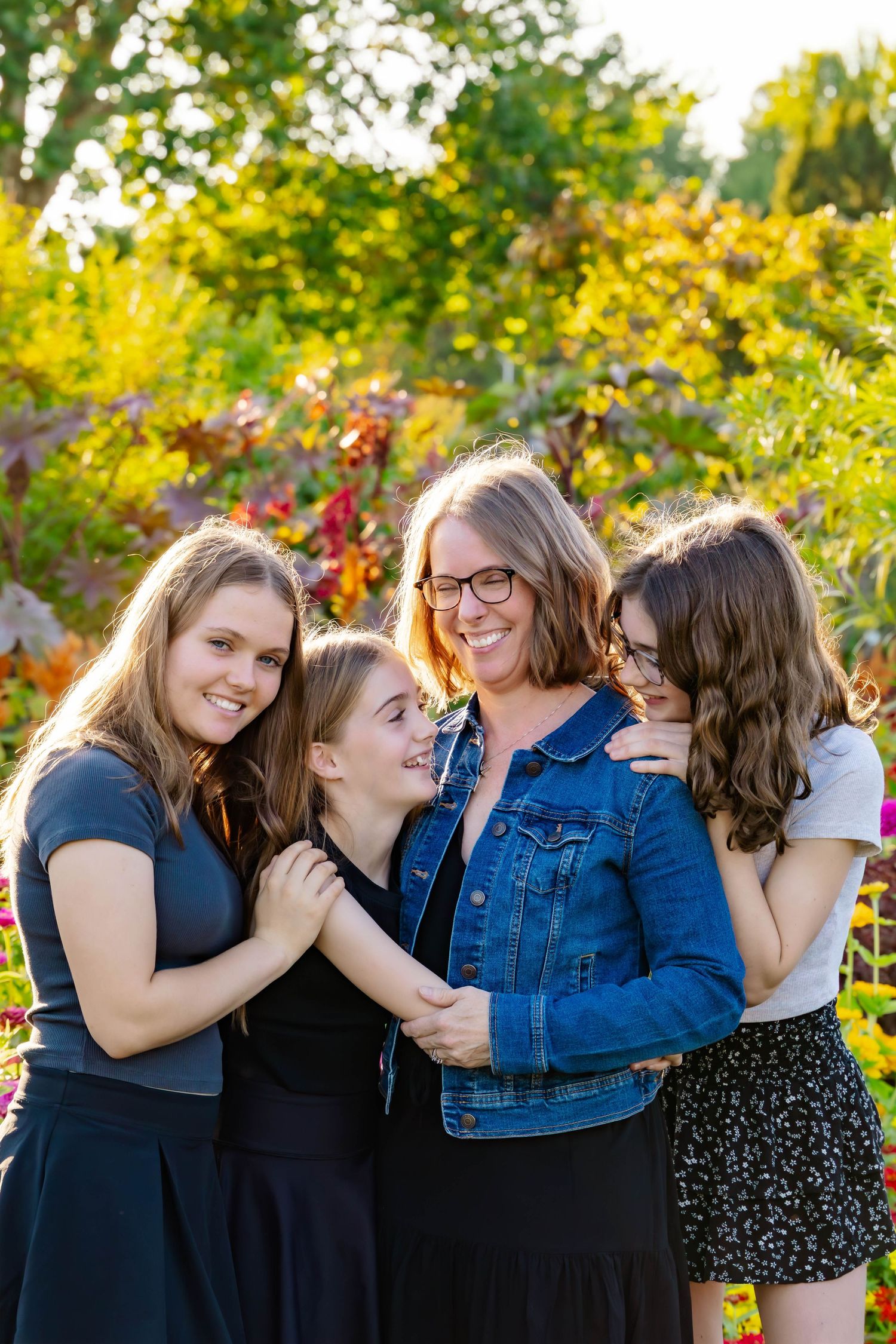 Friends share embraces and laughs during an outdoor photo session with autumn colors in the background.