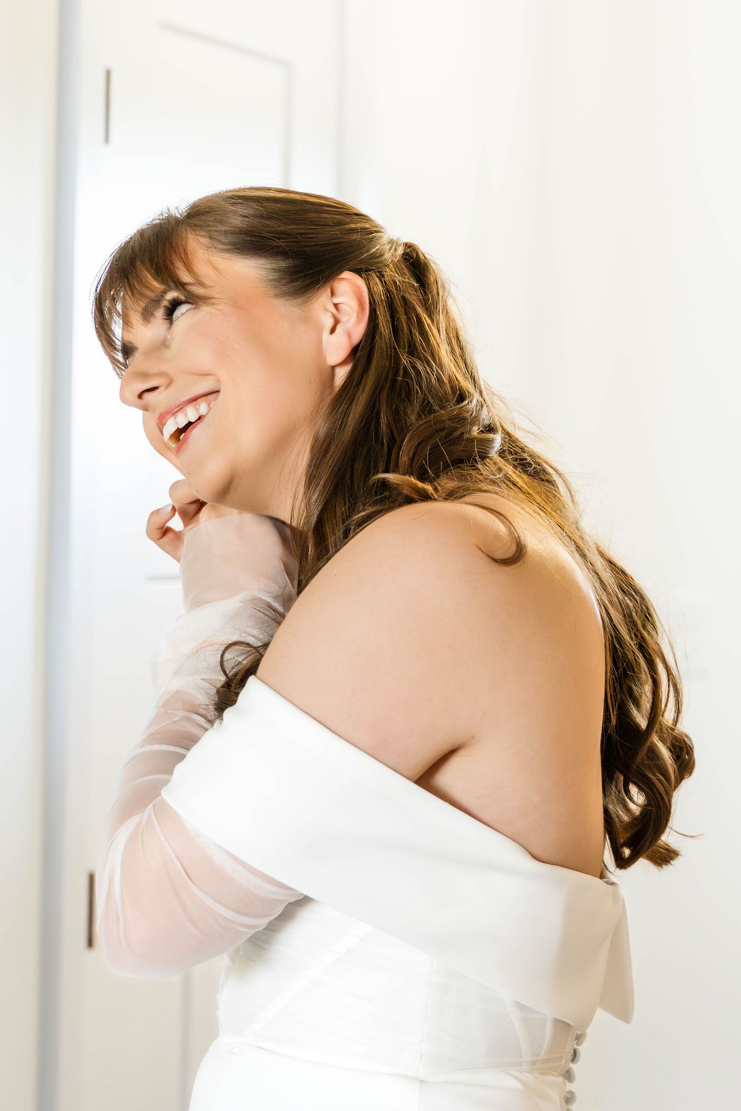 Bride in off-shoulder white dress showing joyful expressions.