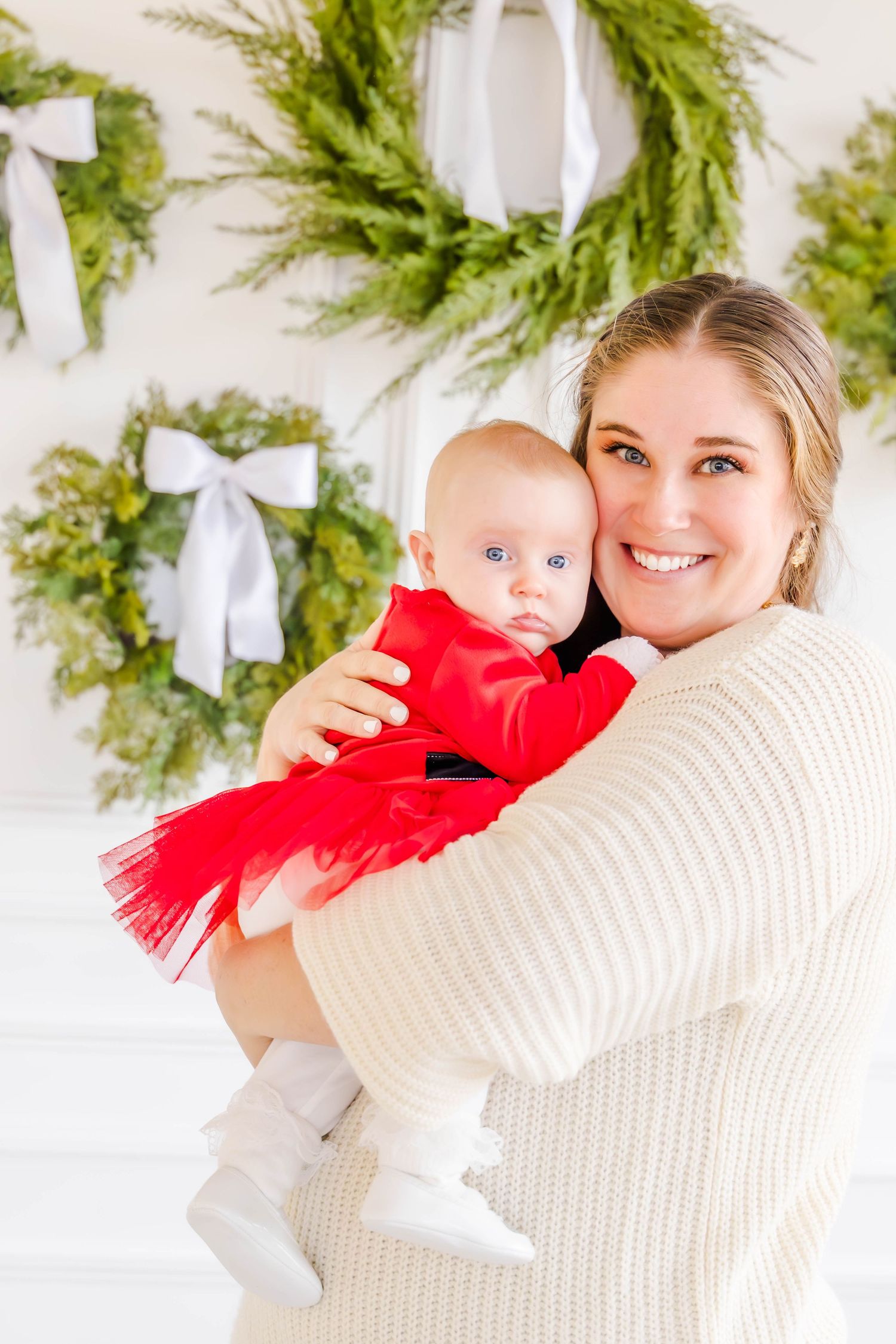Holiday portraits with evergreen garland decorations in background.