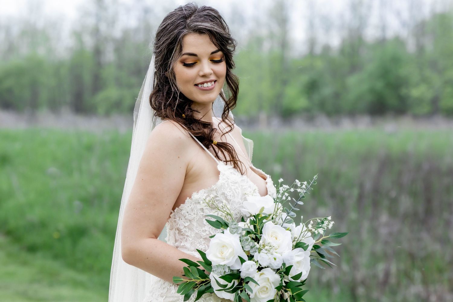 Elegant bridal portrait in a spring garden setting with white floral bouquet.