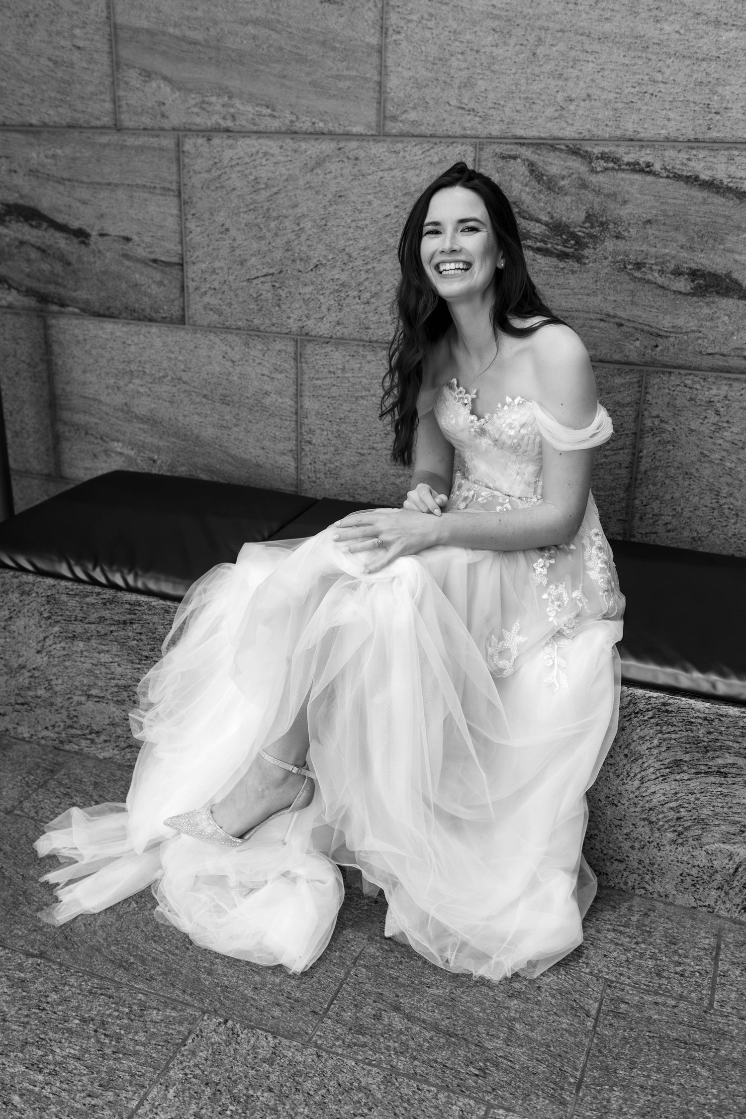 A series of black and white photos showing someone in a white wedding dress sitting on stone steps.