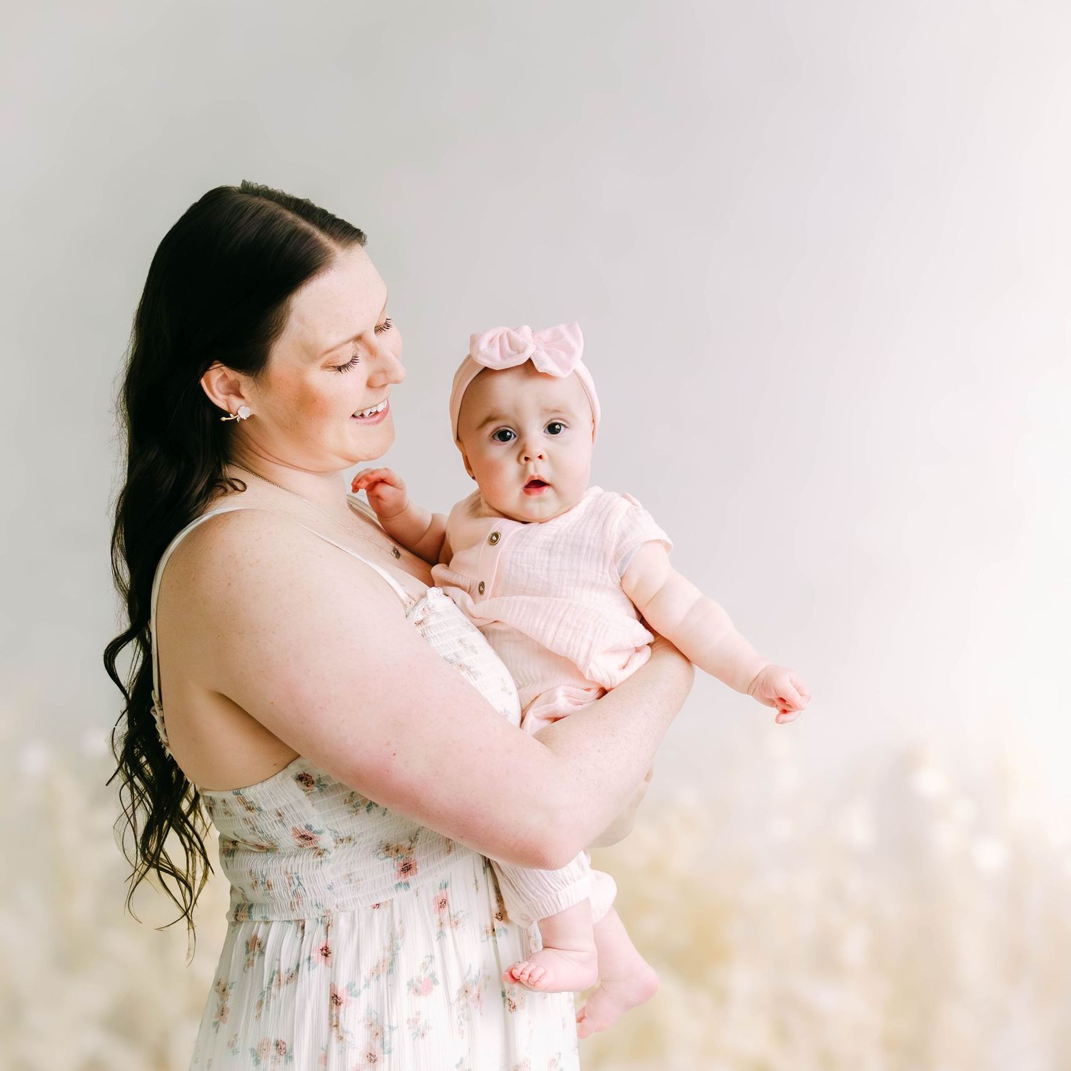 Tender moments captured in soft lighting with floral studio decorations.