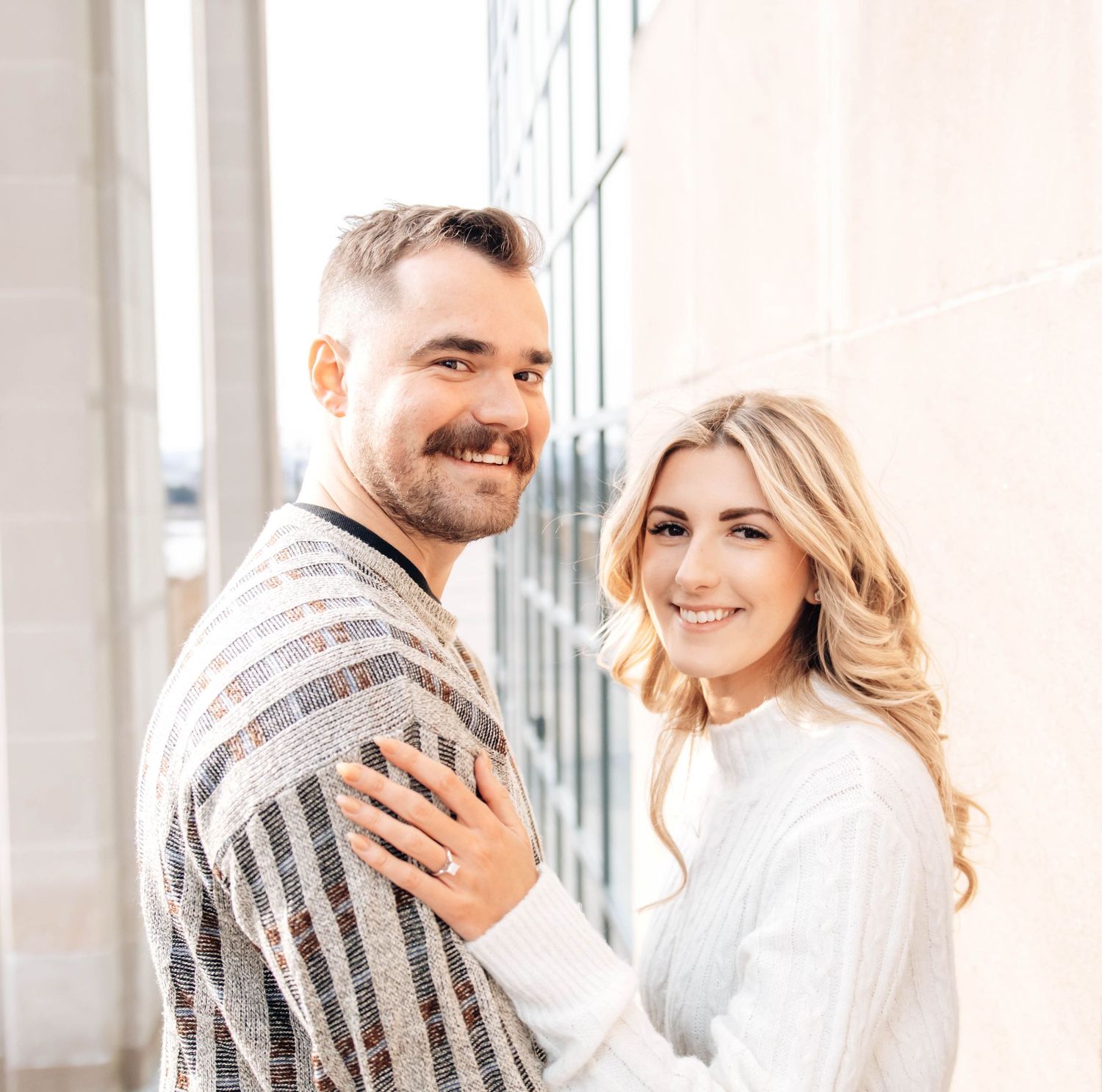 A bright indoor photoshoot showing tender moments between a couple in casual attire.