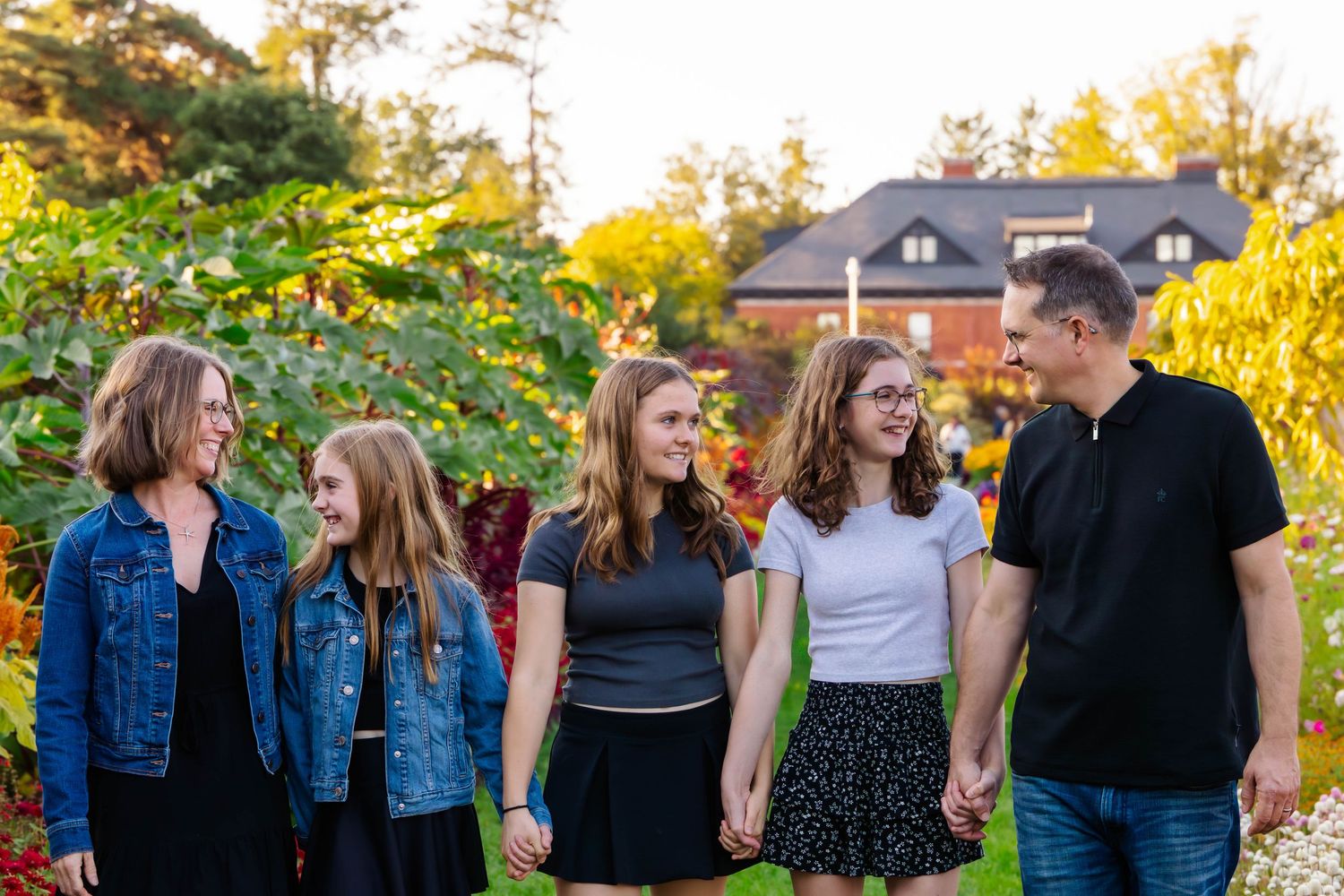 Casual family group photo shoot in garden during sunset golden hour.