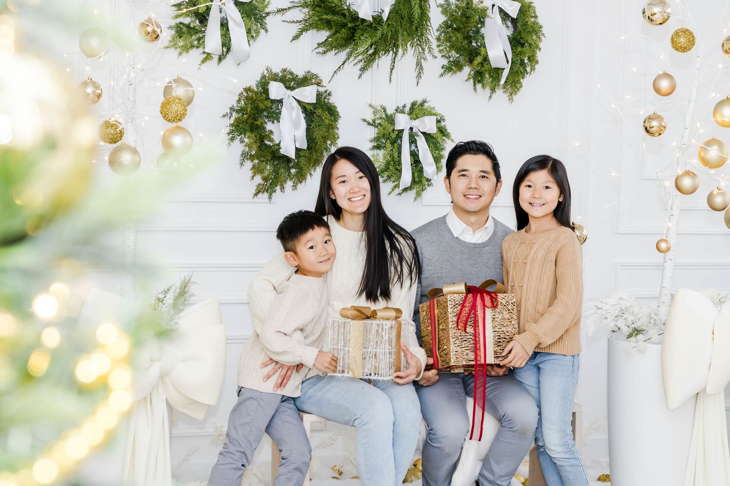 Family portrait session with Christmas decorations and gold ornaments.