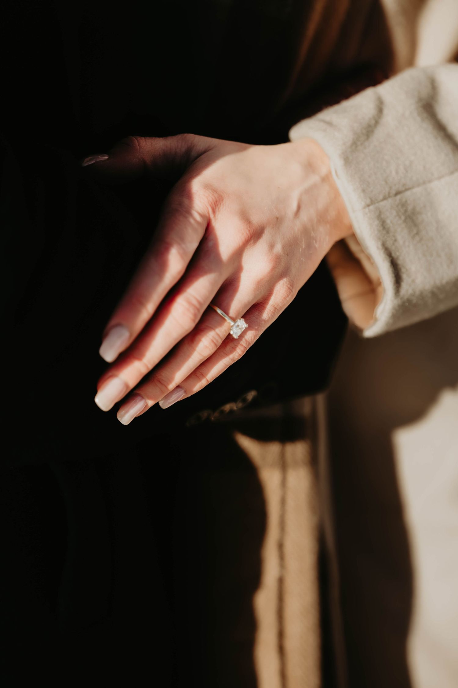Close-up shots of hands wearing a gold ring against a beige and dark background in various artistic poses.