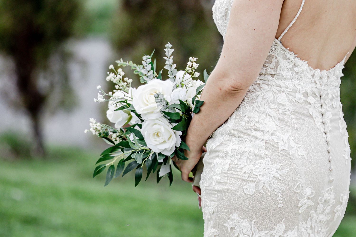 Wedding dress details show intricate white lace patterns against a neutral beige background.
