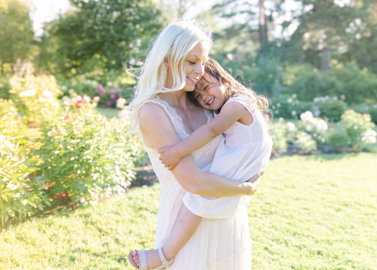 Tender moment captured in sunlit garden setting.