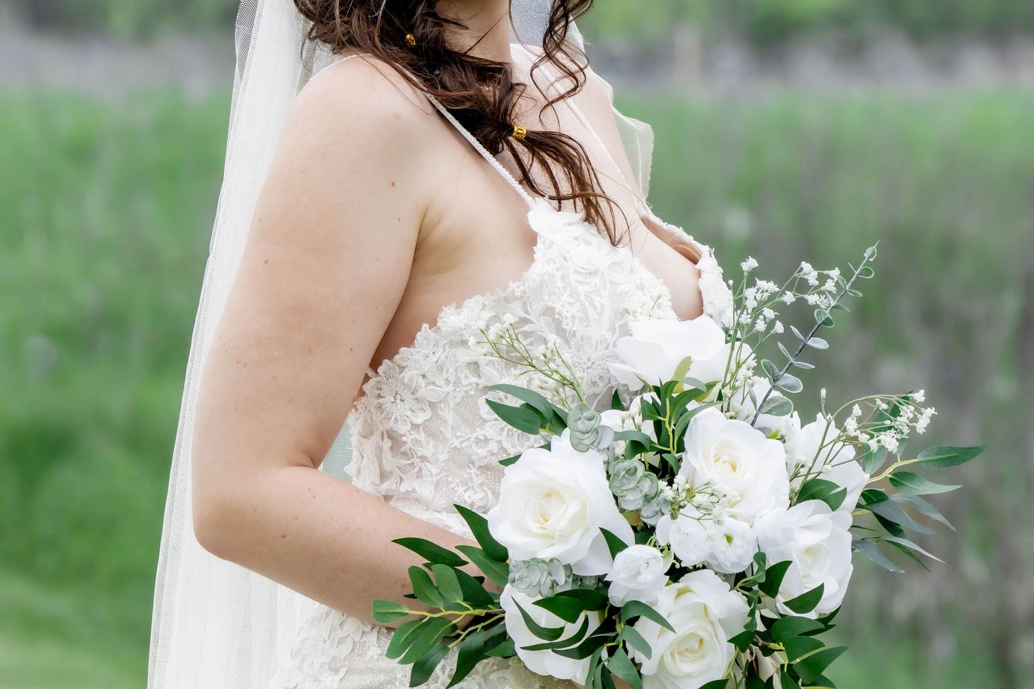 Elegant white bridal bouquet featuring roses, eucalyptus and delicate greenery.