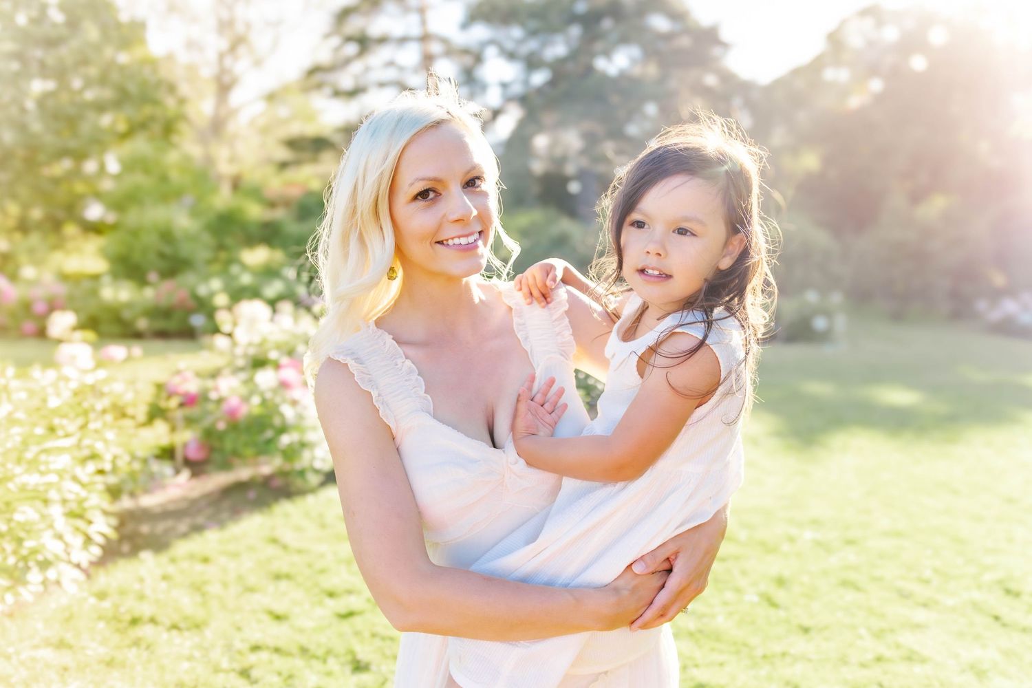 Joyful outdoor portrait session in a lush garden setting during golden hour.