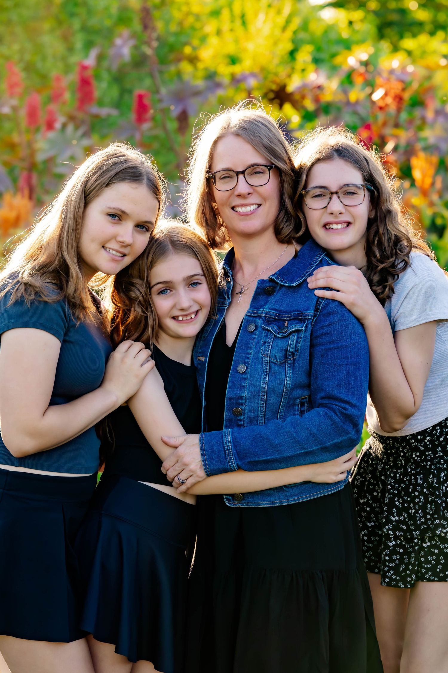 A group photo session in front of fall foliage featuring casual outfits and denim jackets.