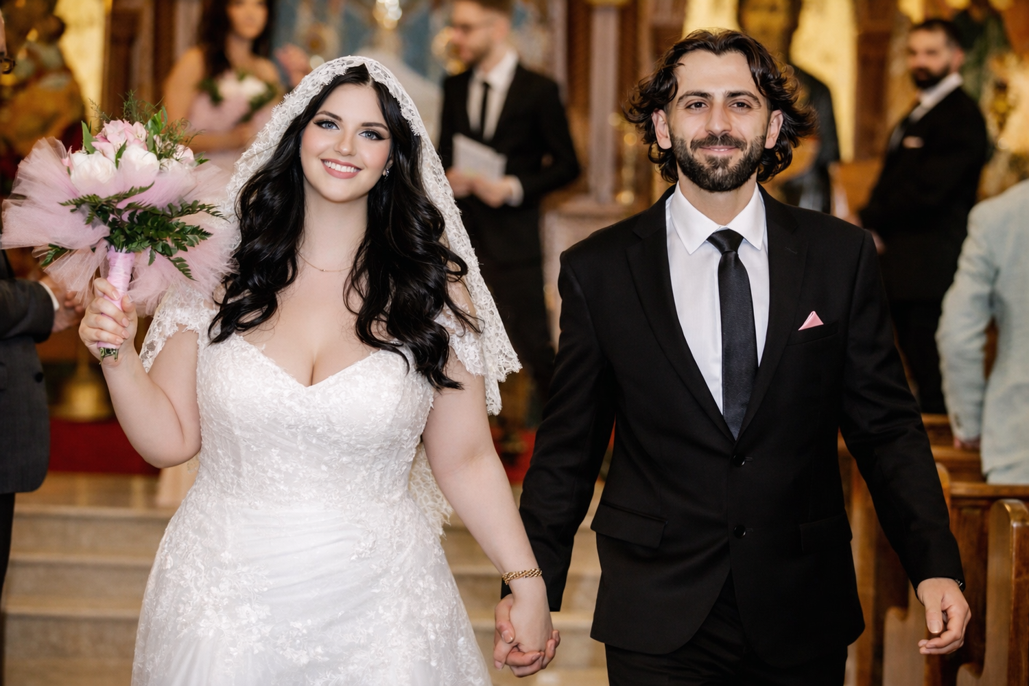A couple walks hand in hand down the aisle after their wedding ceremony, with the bride in white and groom in black.
