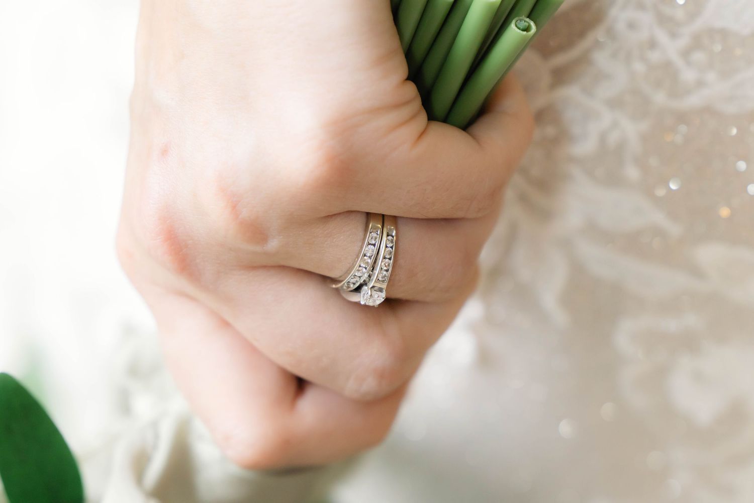 Close-up of a sparkling diamond engagement ring on a bride's hand.