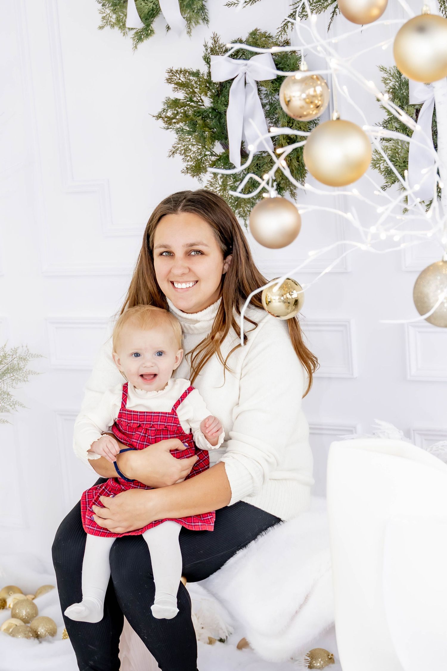 Holiday family photo with white and gold Christmas decorations and ornaments.
