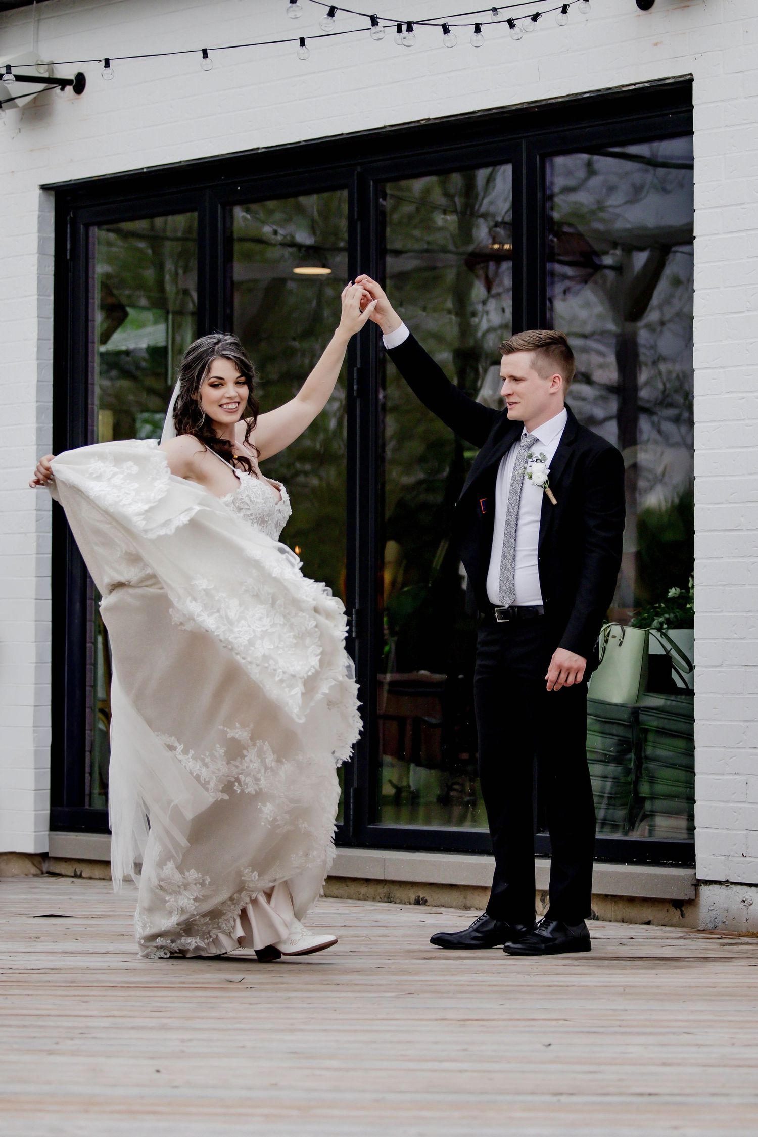 Dynamic wedding dance poses photographed on outdoor wooden deck.