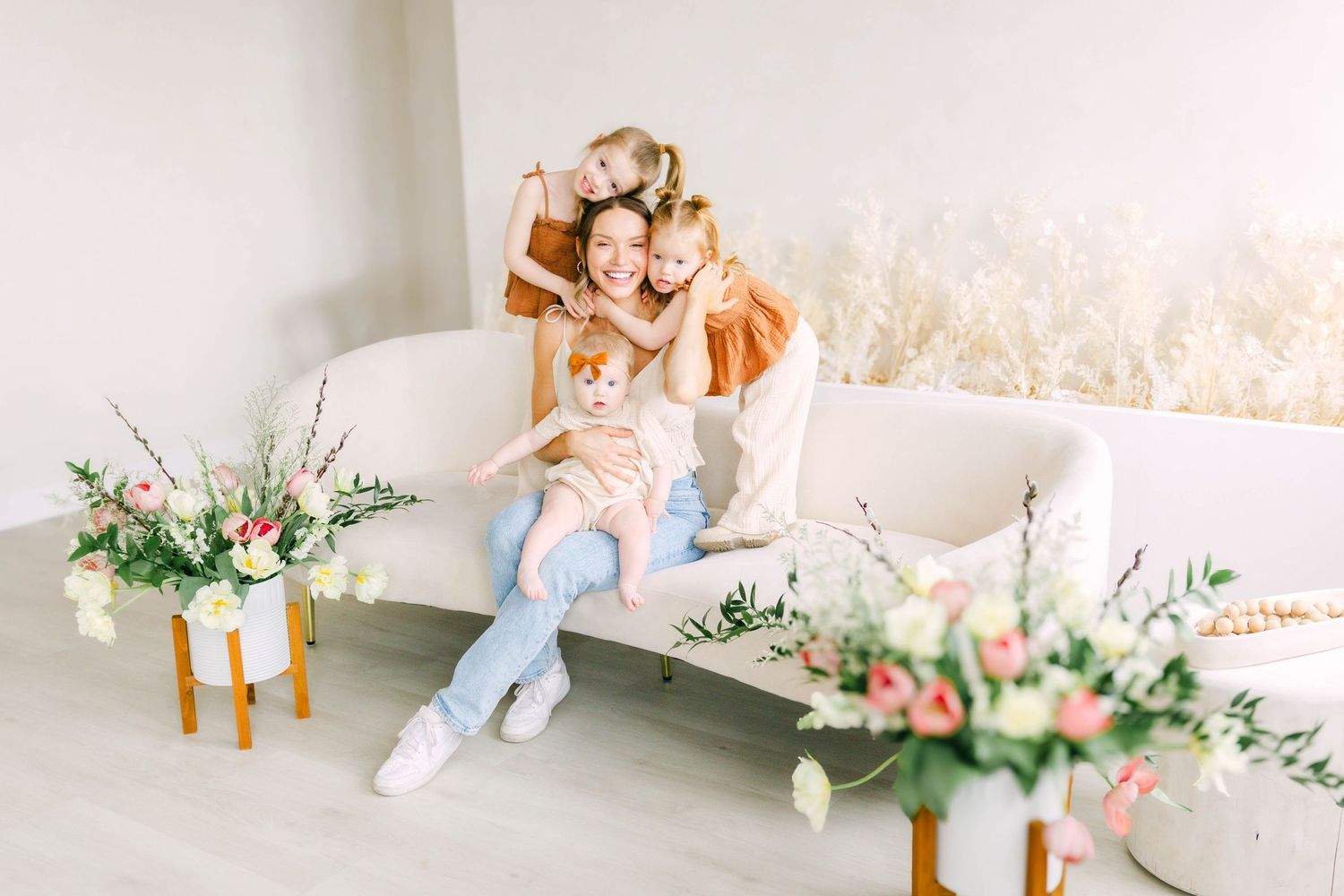 A person sits in a bright interior space decorated with floral arrangements.