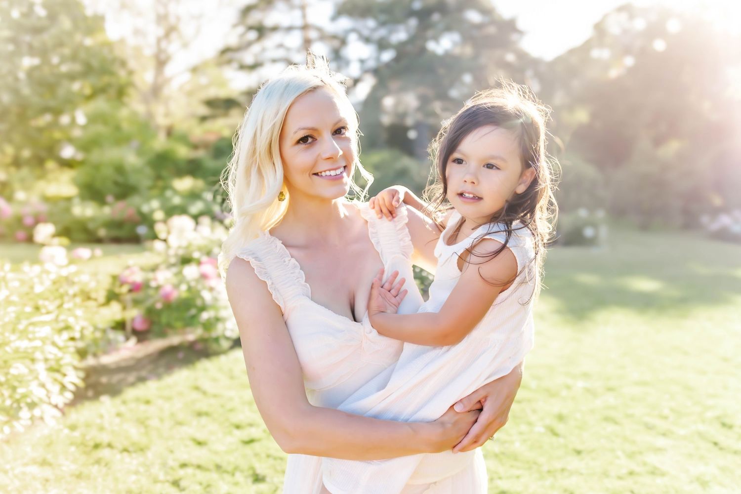 Mother and child share joyful moments together on sunny day outdoors.