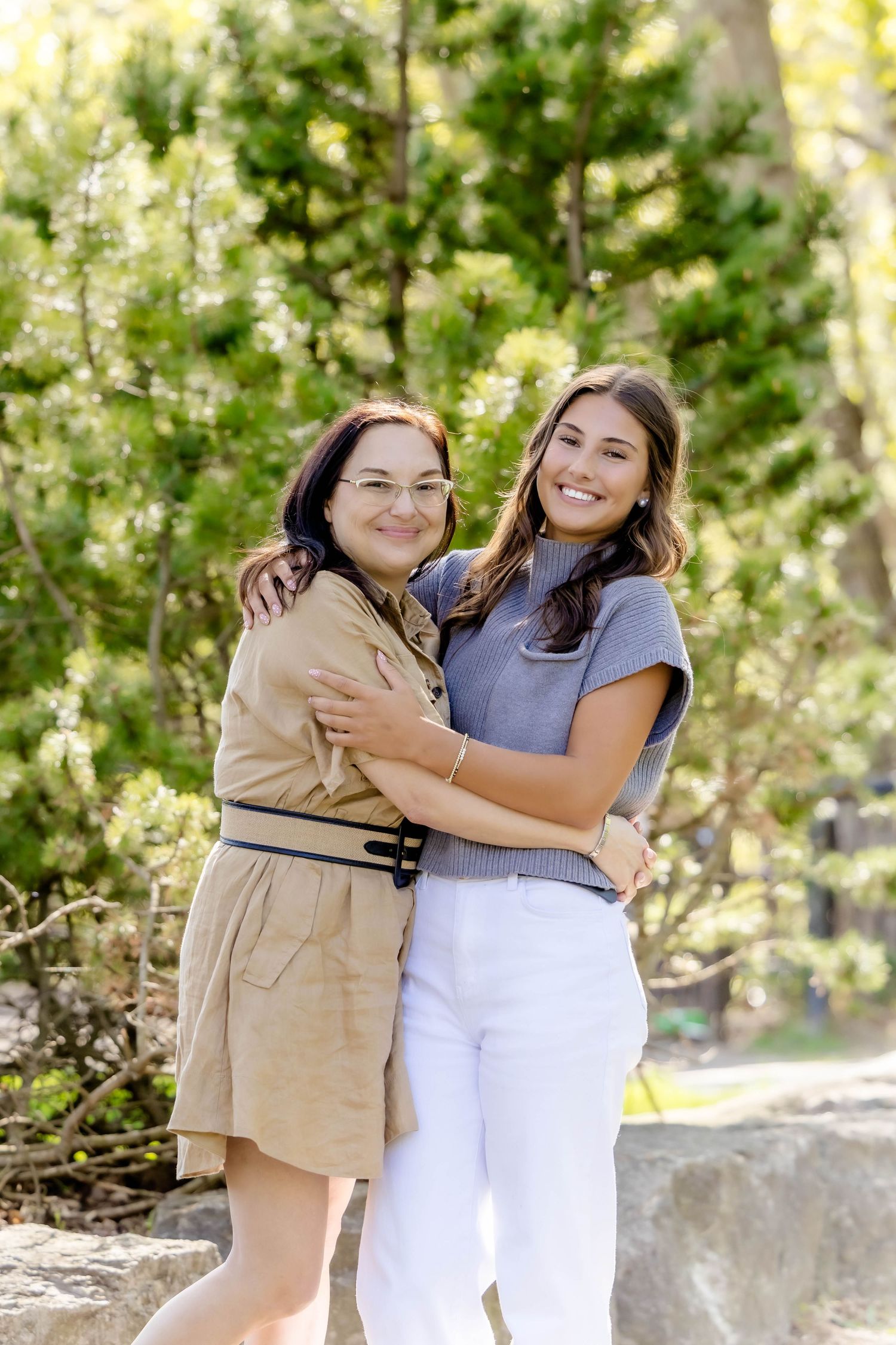 Two people embrace while wearing coordinated outfits during an outdoor photo session.