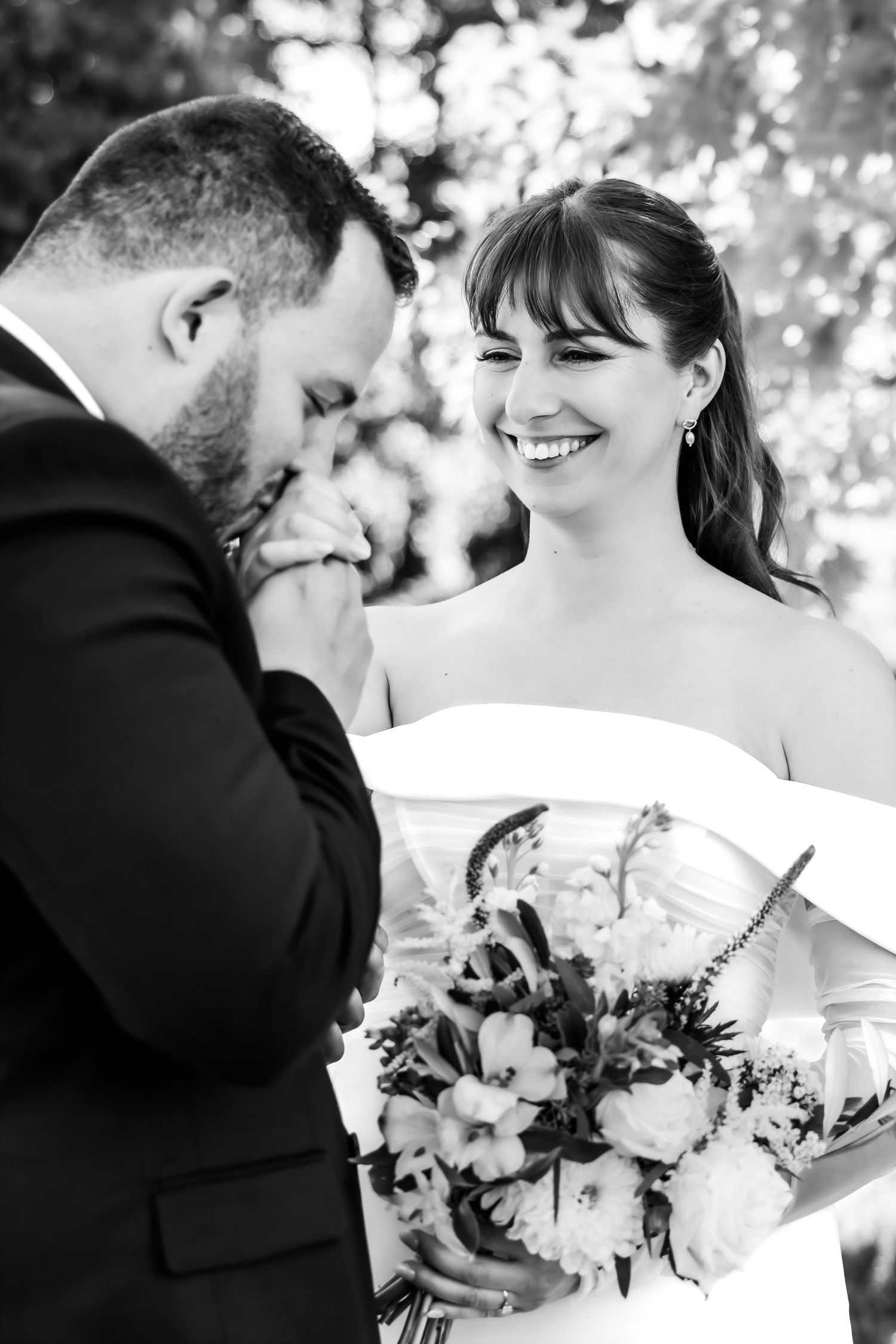 Romantic black and white wedding sequence showing tender moments and floral bouquets outdoors.