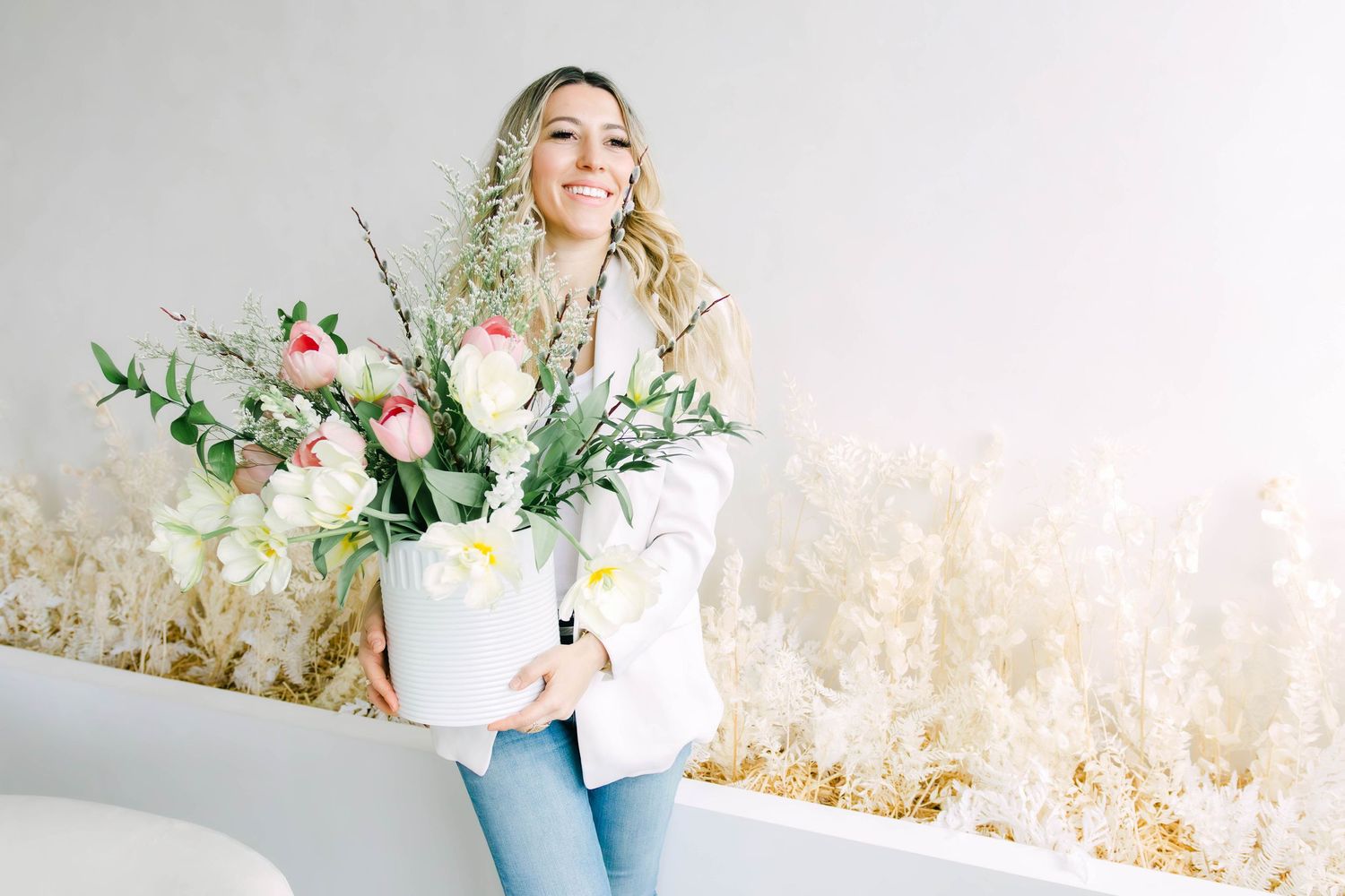 A series of soft, romantic floral arrangements with white roses and greenery in pastel blue vases against a light backdrop.