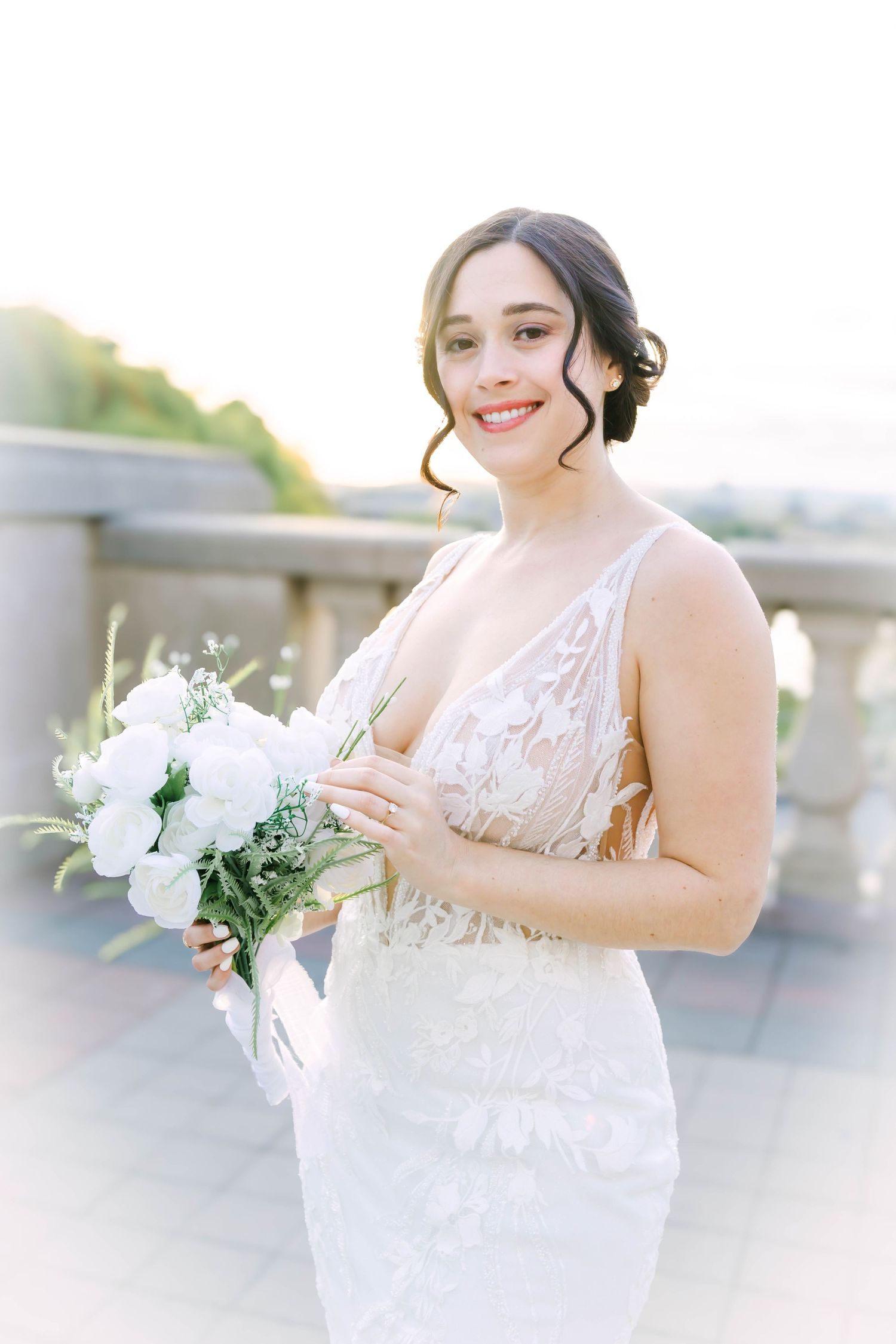 Dreamy bridal photos showing detailed lace dress and fresh white floral arrangement.