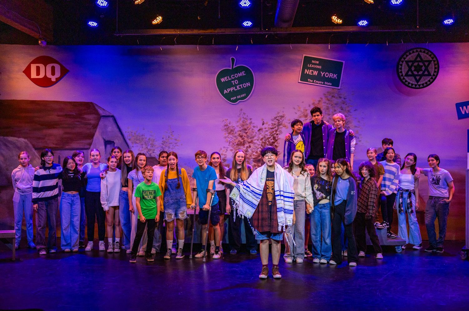 Ensemble cast performing on stage in Kirkland