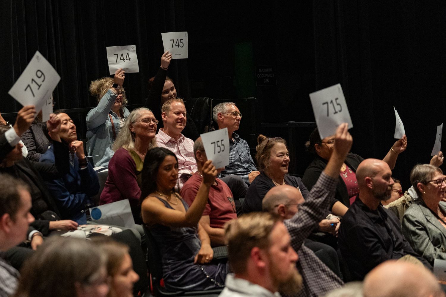 Audience raising the paddle at event in Bellevue